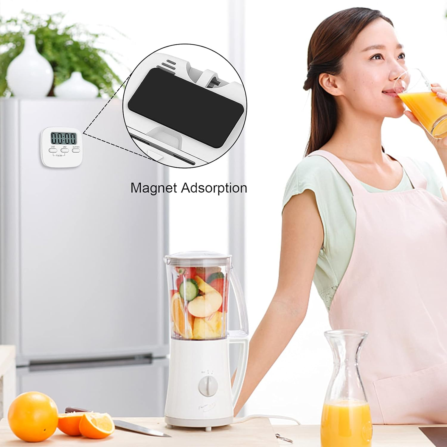 Eine Frau trinkt Orangensaft neben einem Mixer mit Obst.