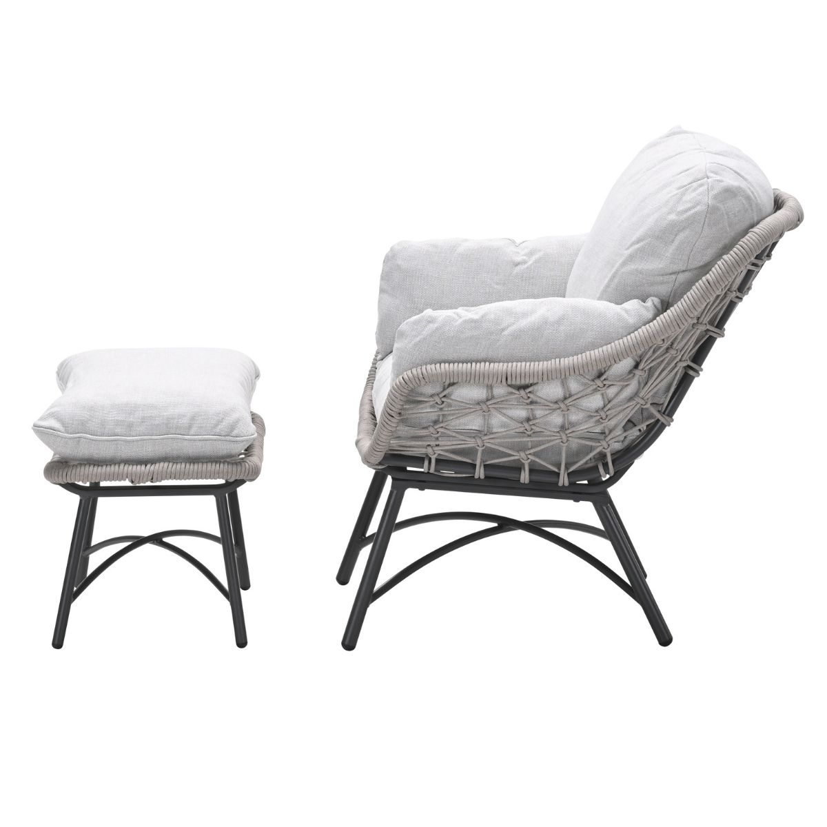 Een grijze rotan fauteuil met kussens en een bijpassende poef.