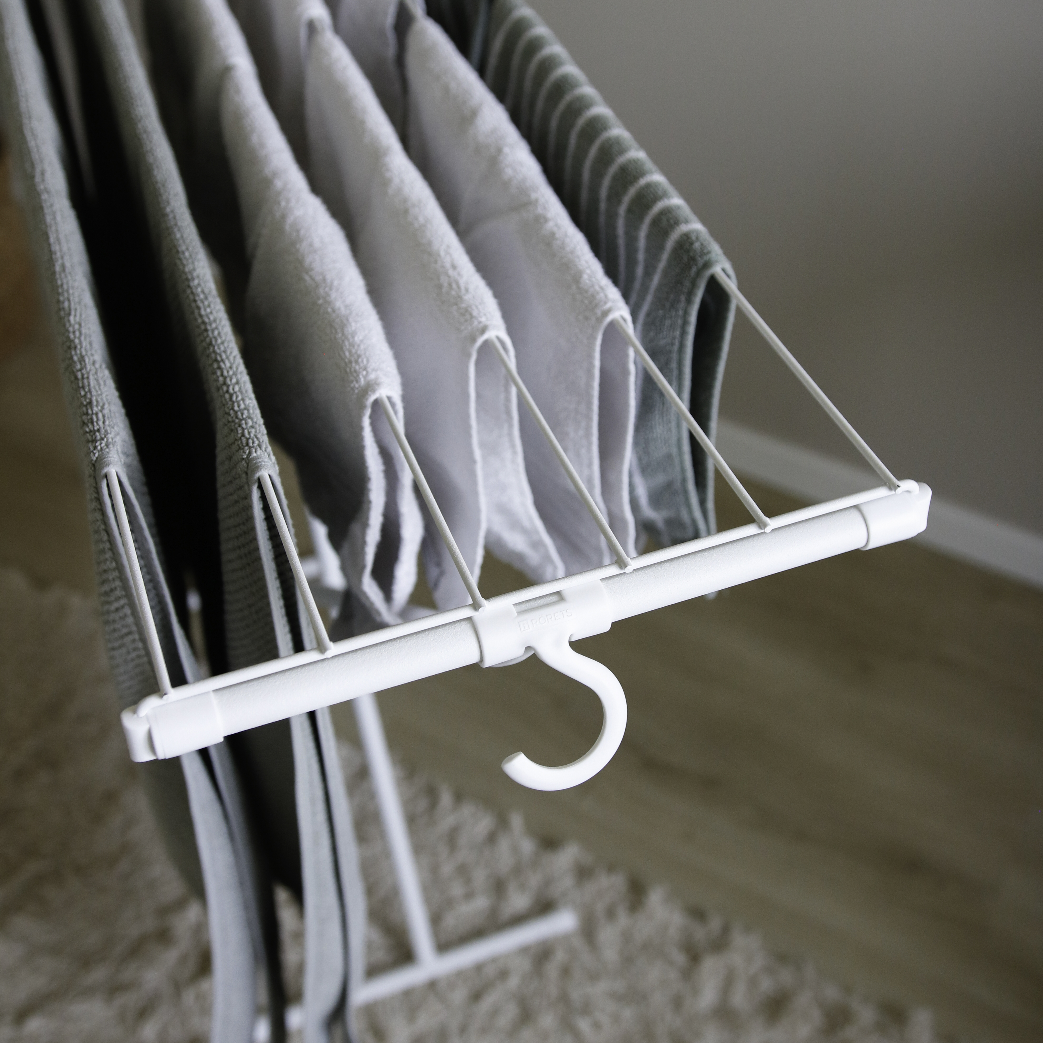 Serviettes blanches et vertes suspendues sur un étendoir.