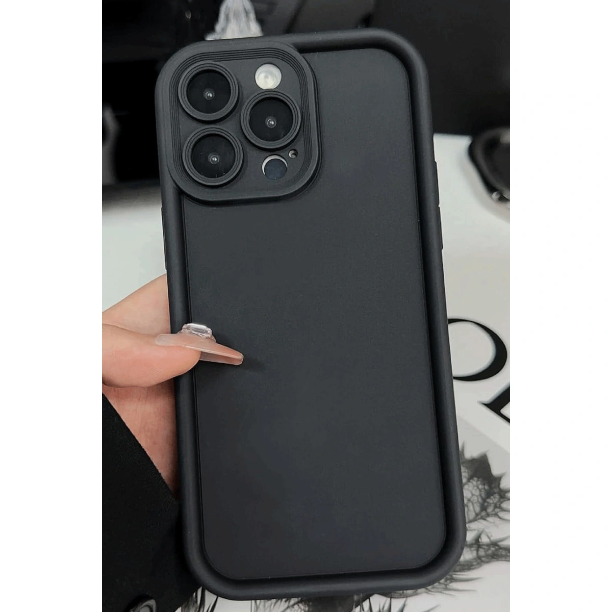 Üç kamera lensi ve flaşlı siyah telefon kılıfı.