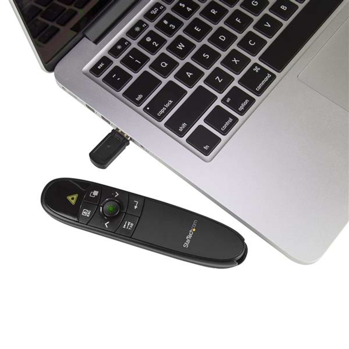 Ein schwarzer Presenter liegt neben einem Silbernen Laptop. Ein USB-Stick steckt im Laptop.