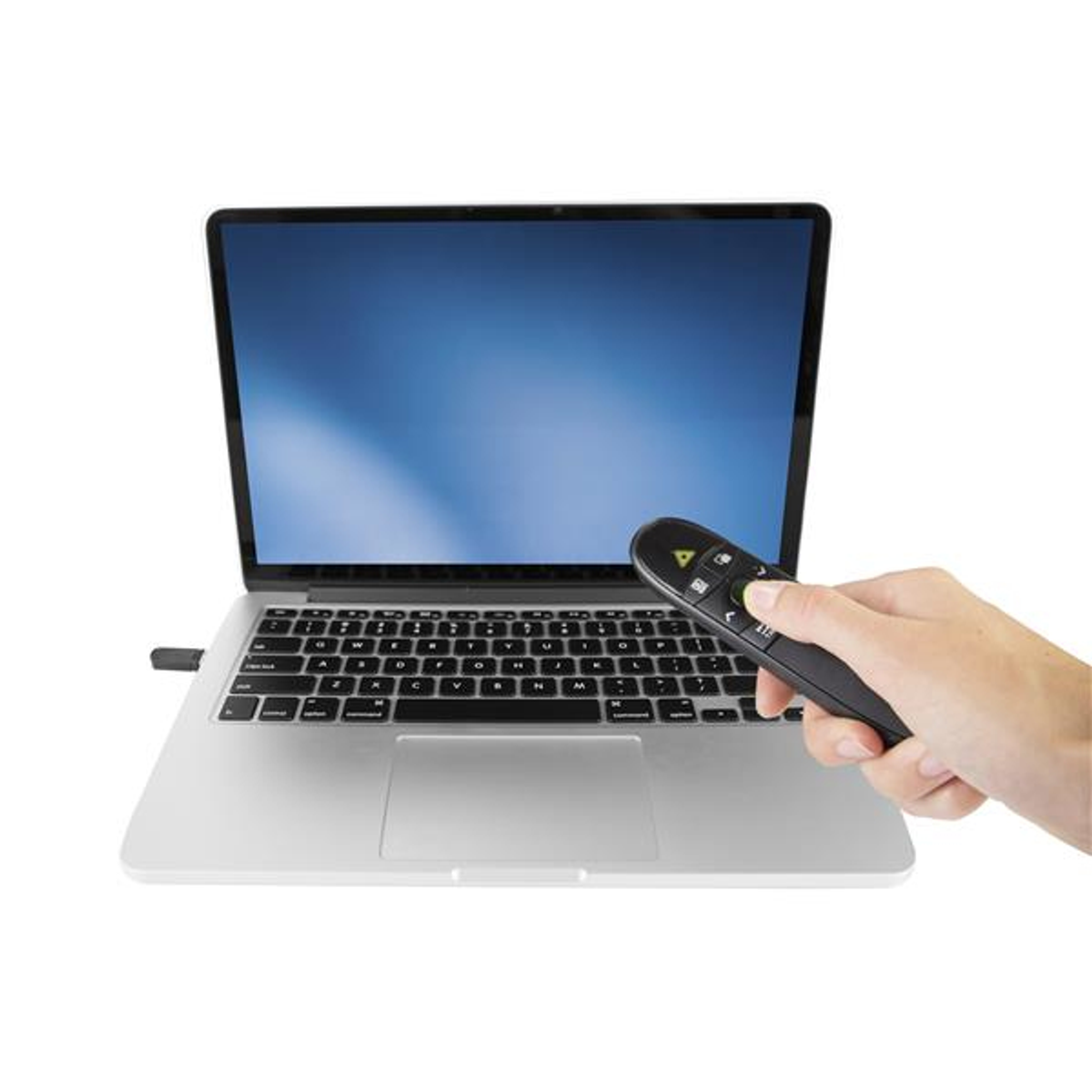Hand hält Fernbedienung über Laptop-Tastatur. USB-Dongle steckt.