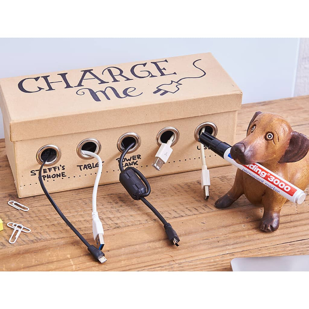 Aufbewahrungsbox für Ladekabel mit Hundefigur und Stift.