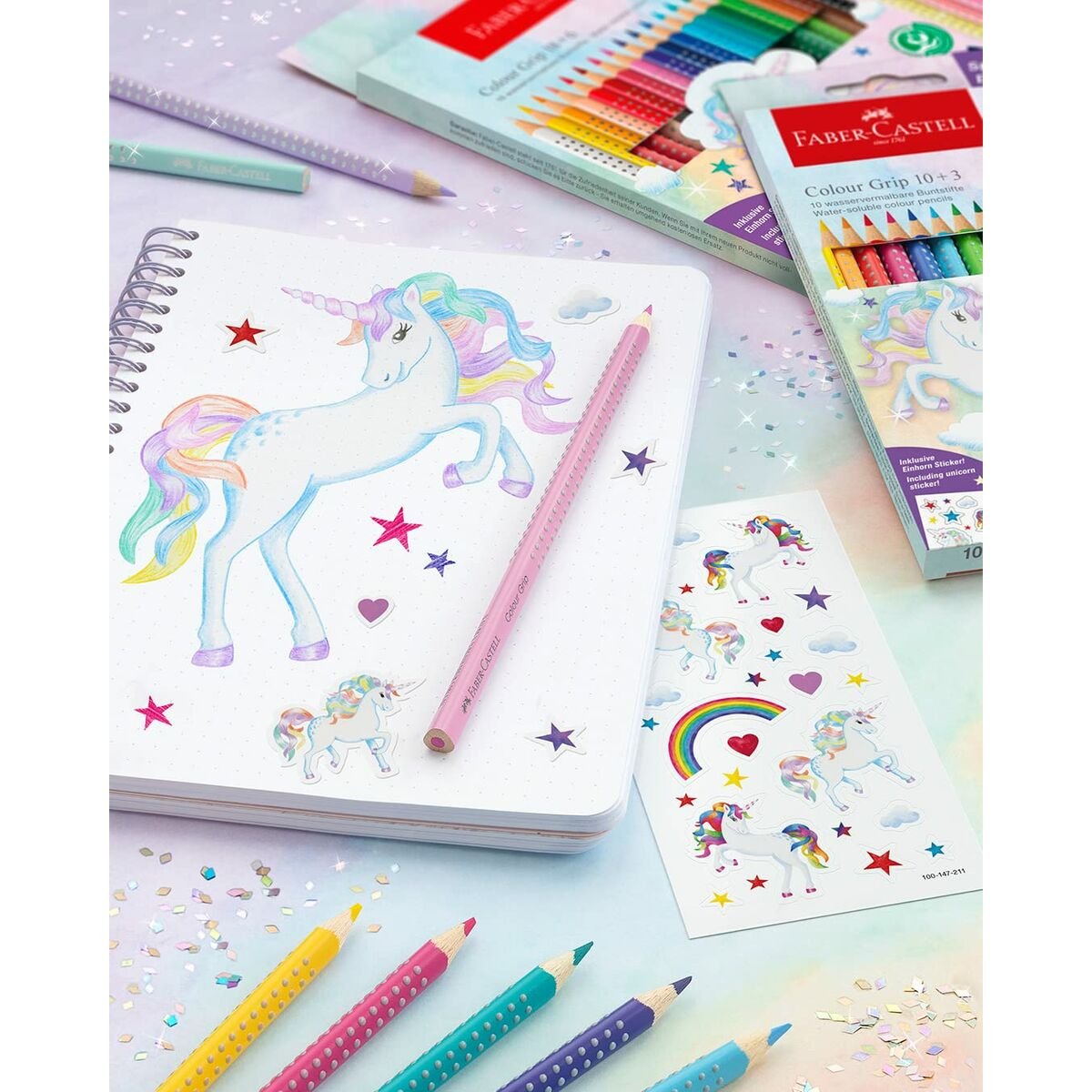 Ein Notizbuch mit Einhorn-Motiv, Buntstiften und Stickern.