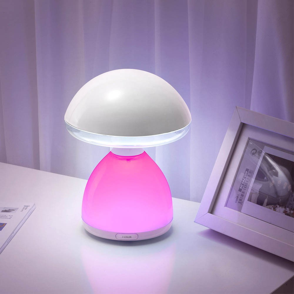 Una lámpara en forma de hongo con cúpula blanca y base rosa sobre mesa.