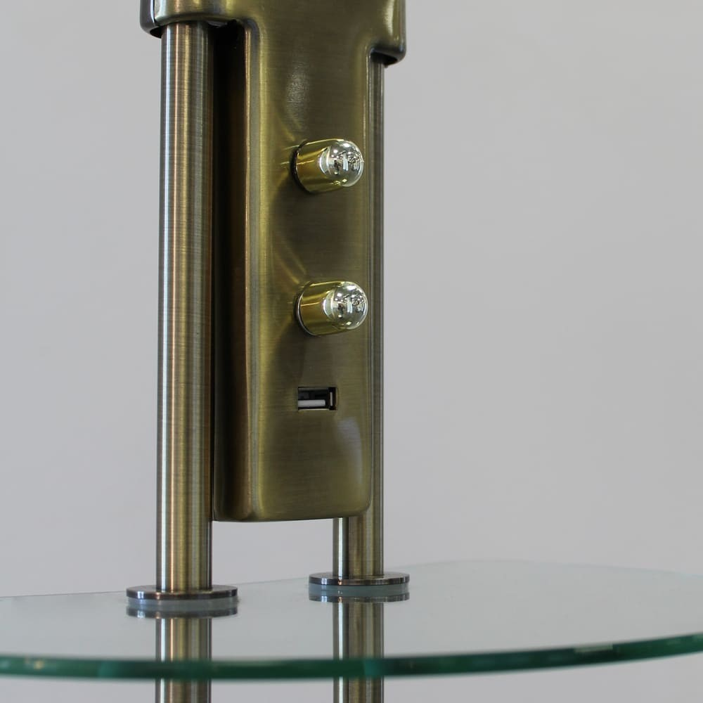 Soporte de color latón con dos perillas y puerto USB sobre estante de cristal.