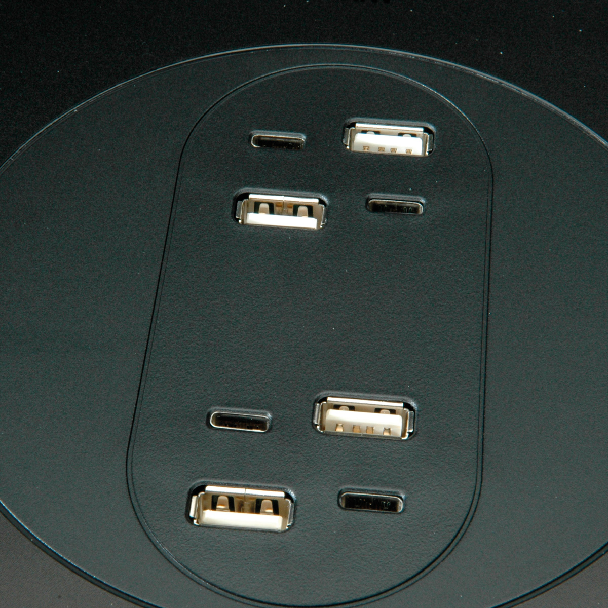 Nahaufnahme einer schwarzen Oberfläche mit vier USB-A- und zwei USB-C-Anschlüssen.