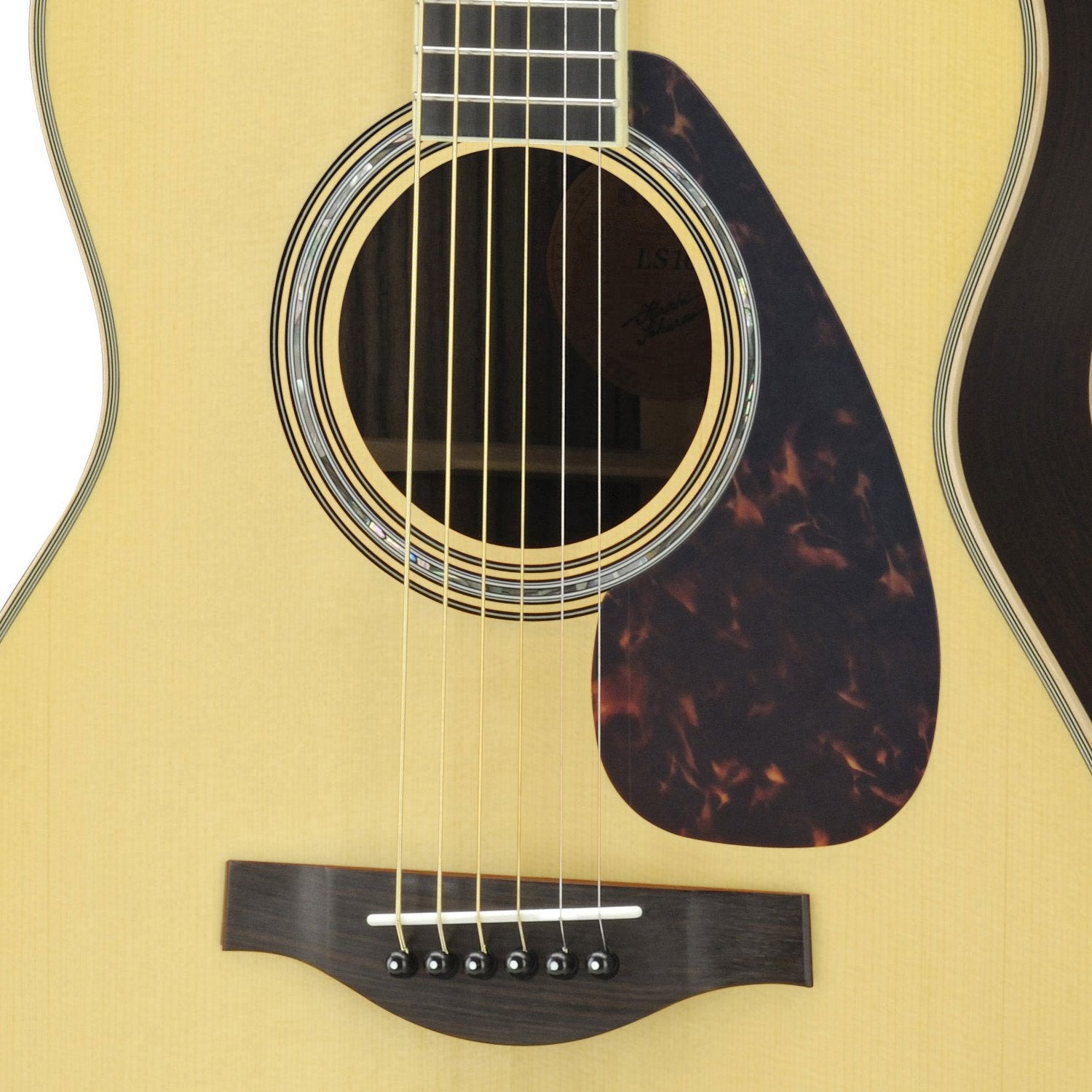 Close-up van een akoestische gitaar met lichtbruin lichaam, klankgat en zes snaren.