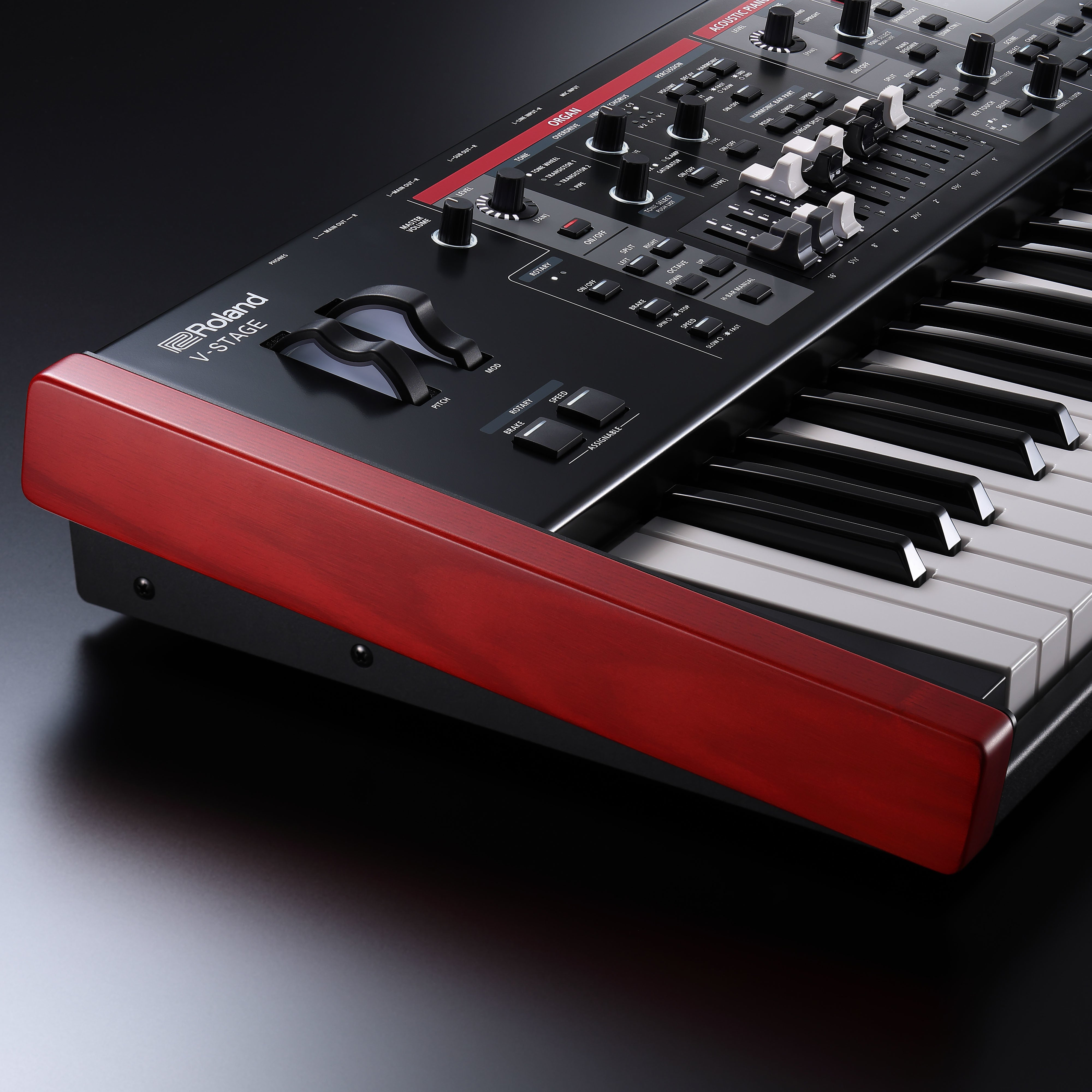 Een zwarte Roland V-STAGE synthesizer met rode houten accenten en vele knoppen.