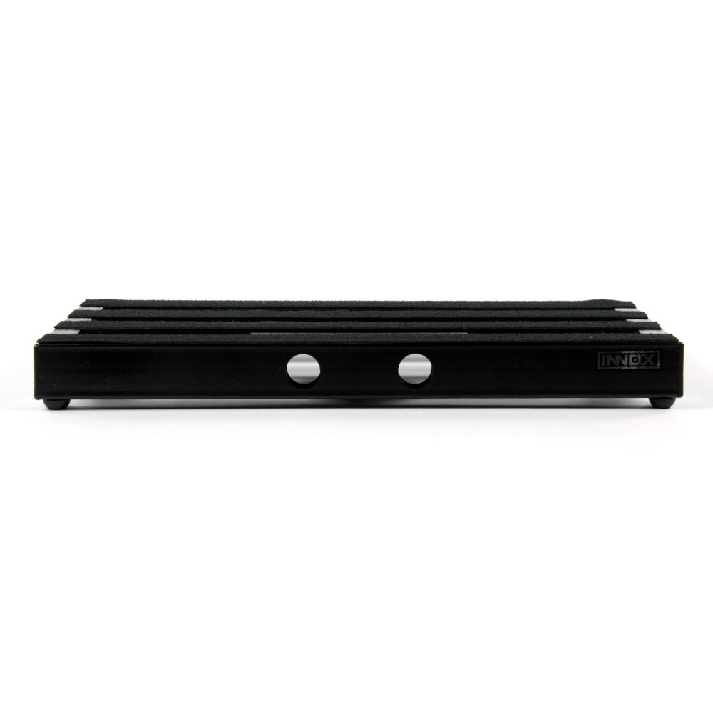Zwart pedalboard met strepen en twee ronde gaten.