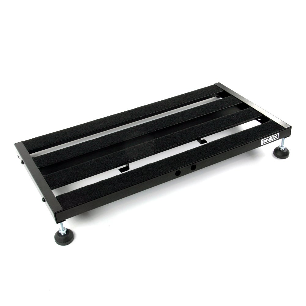Zwart gitaarpedaalbord met vier rubberen voetjes en klittenbandstrips.