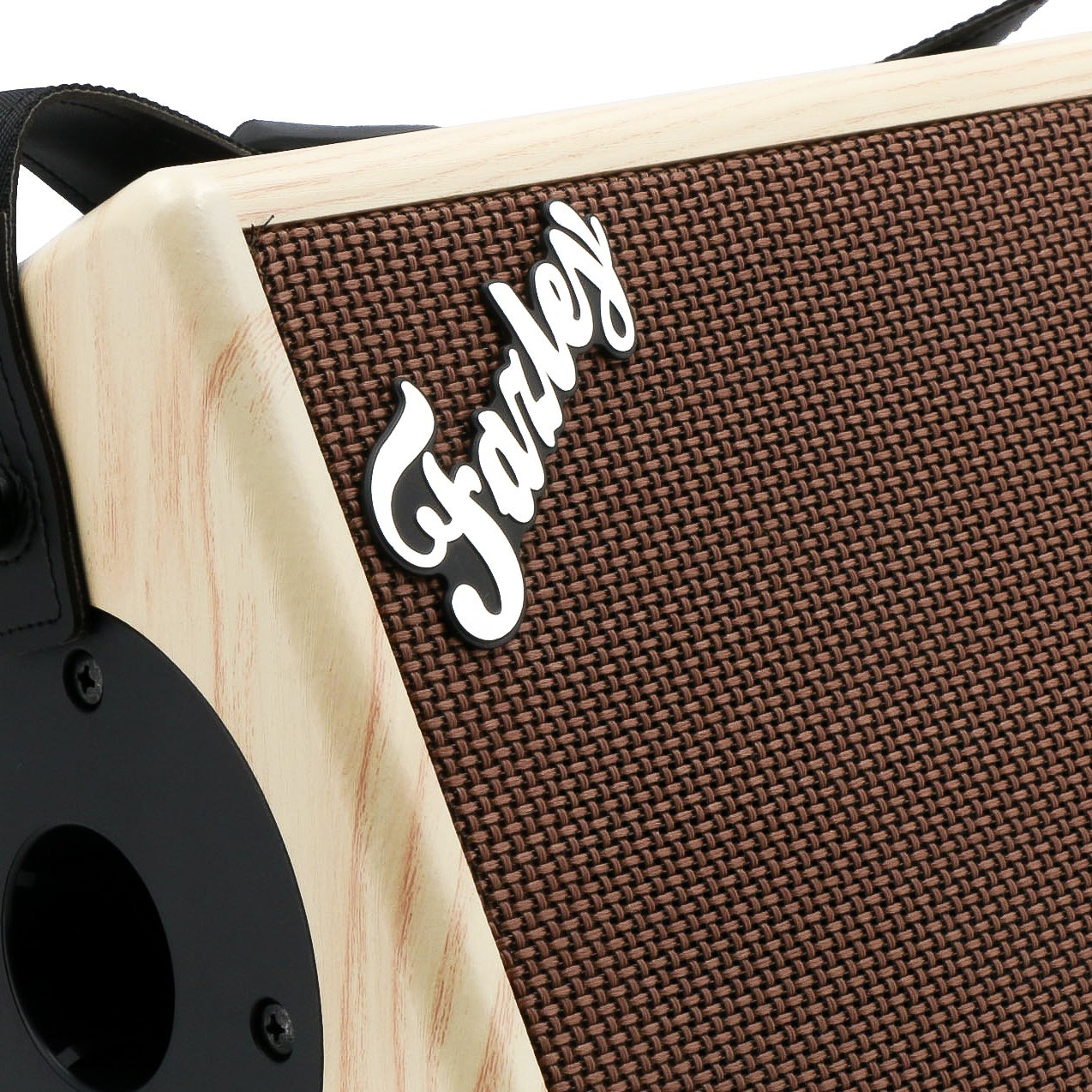 Close-up van een bruin luidsprekerrooster met lichte houten behuizing en het 'Farley'-logo.