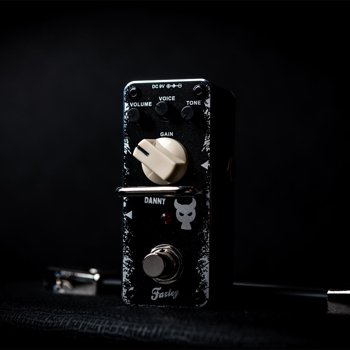 A black guitar effect pedal with white lettering and a white knob.