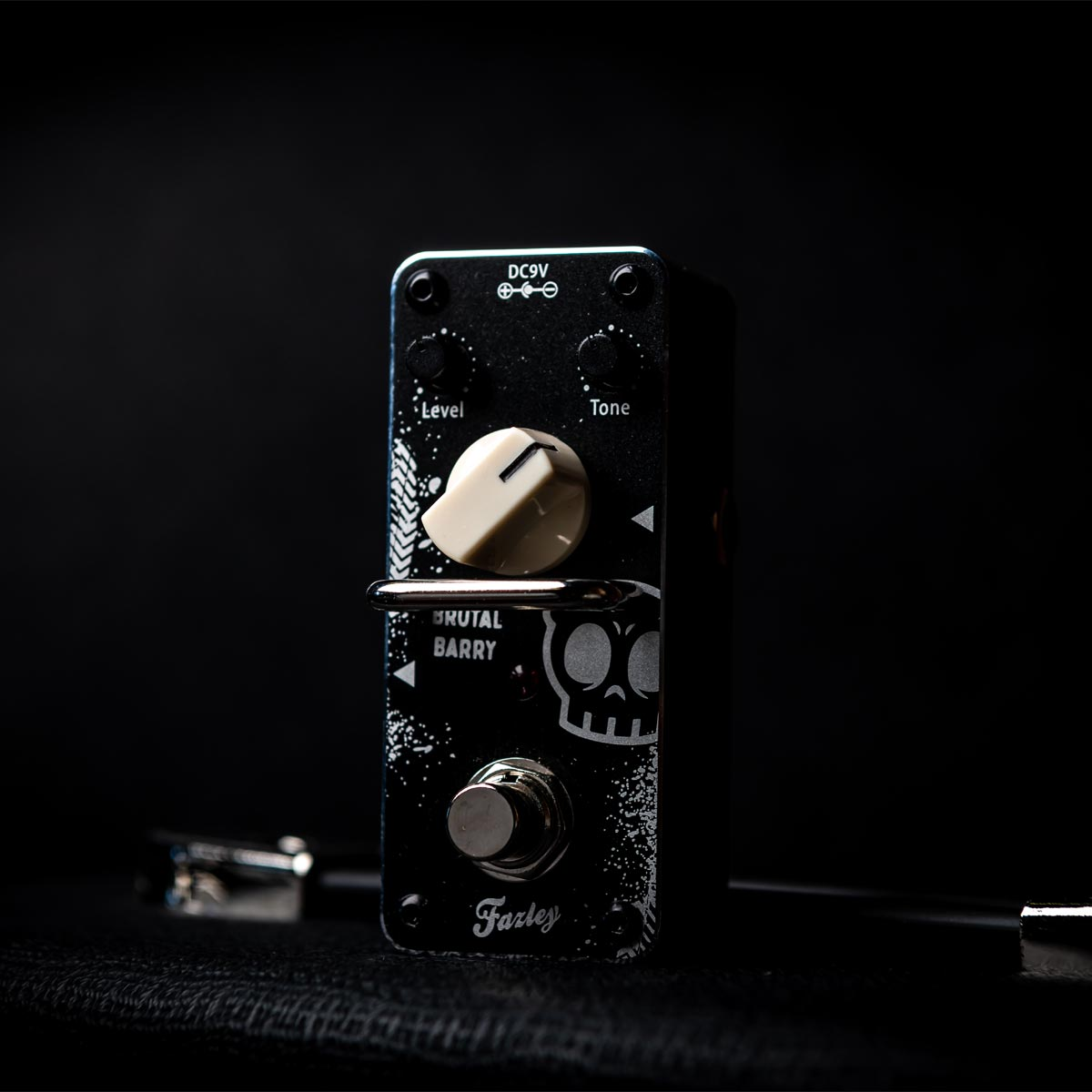 A black guitar effect pedal featuring a skull design and control knobs.