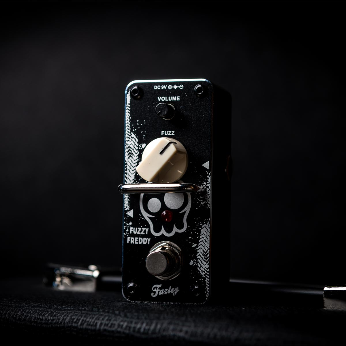 Black guitar effect pedal with skull design, white knobs, and silver footswitch.