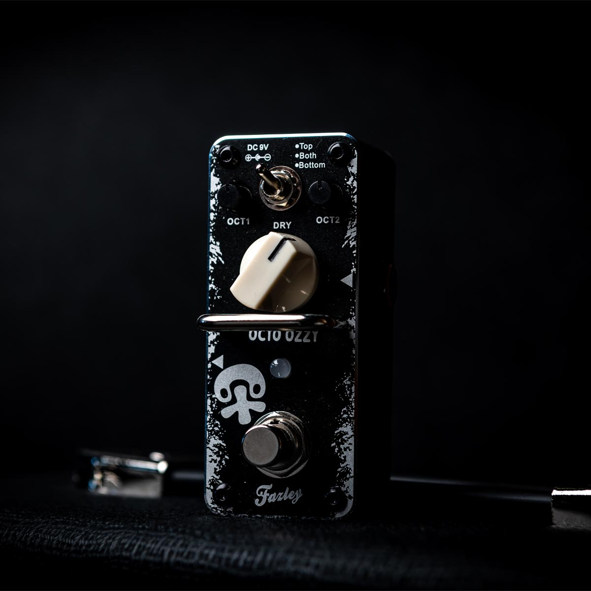 A black guitar effect pedal with silver lettering and knobs on a dark background.