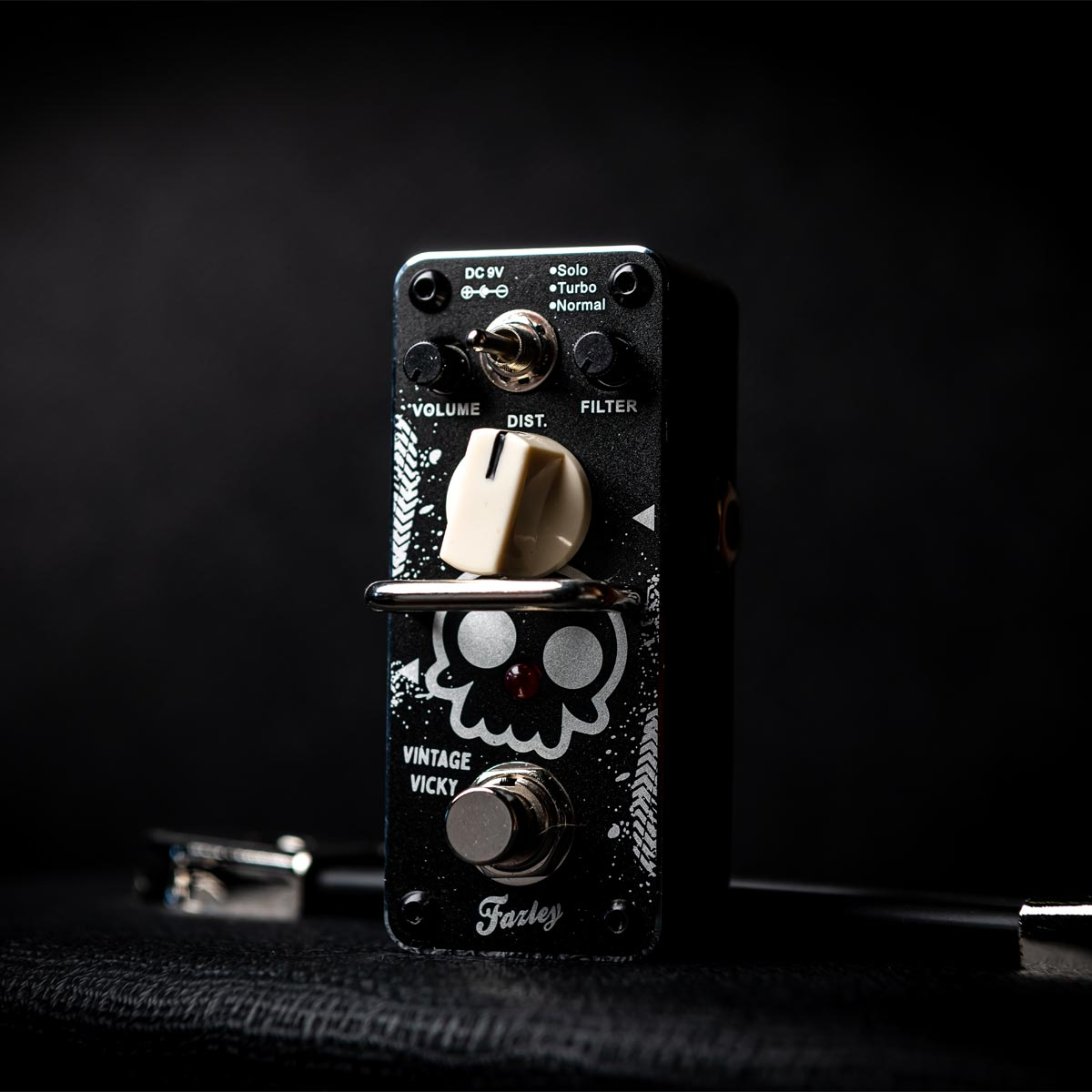 Black guitar effects pedal with skull design, knobs, and switch.