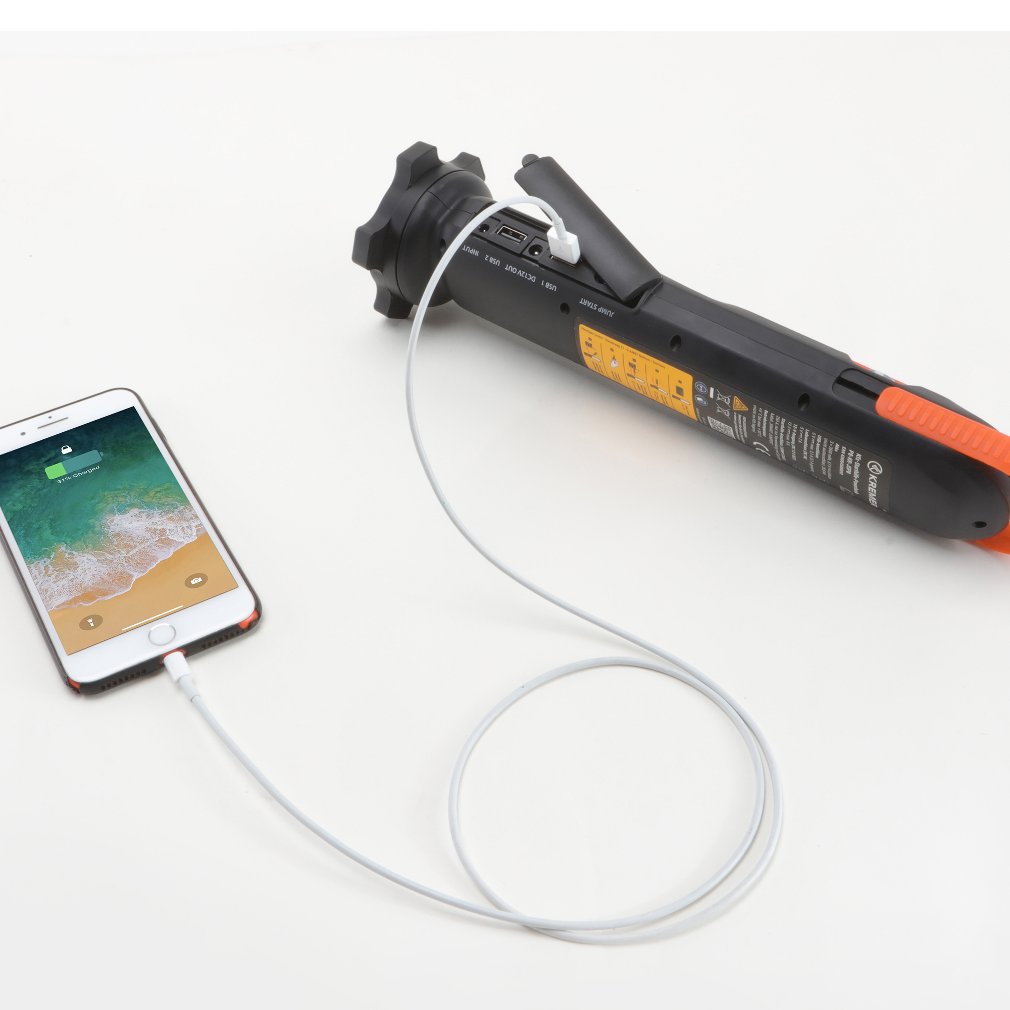 Ein Smartphone wird von einem schwarzen Powerbank-Gerät mit Strom versorgt.