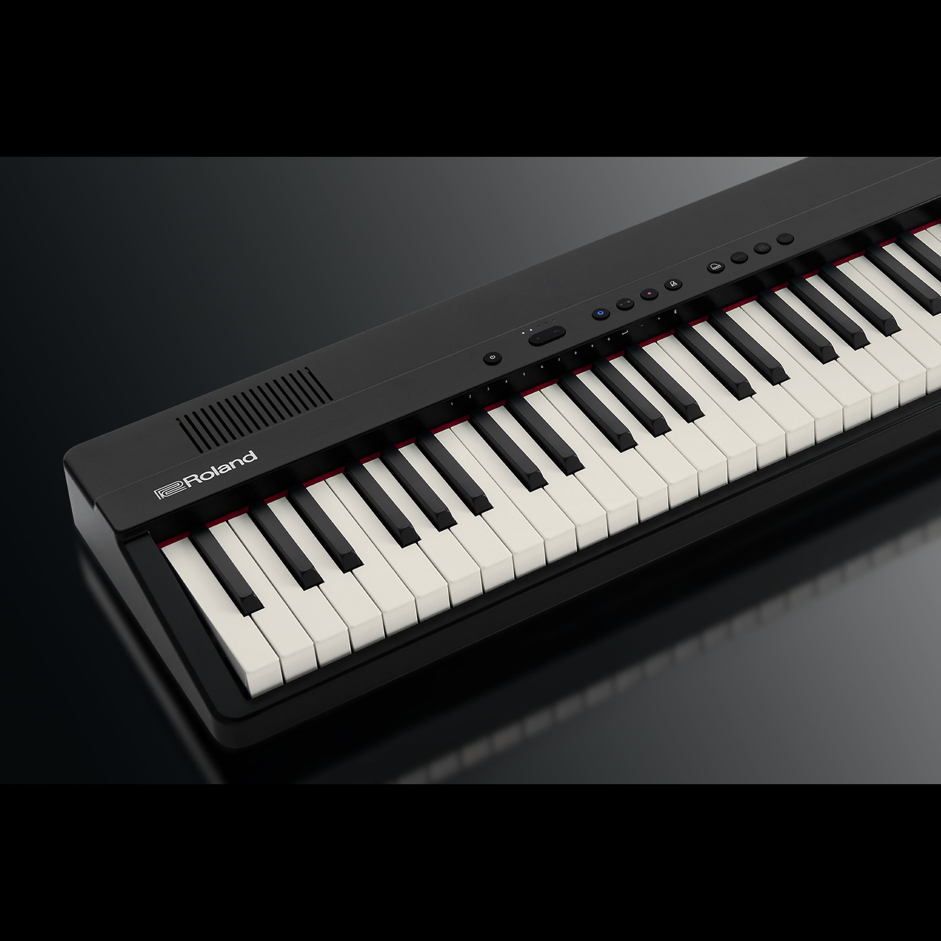Piano numérique Roland noir avec touches blanches et noires, sur fond sombre.