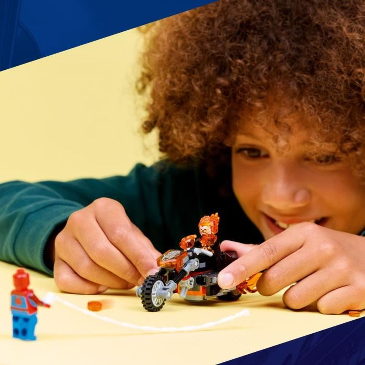 Bir çocuk Lego figürleriyle oynuyor: Spiderman ve Ghost Rider motosiklette.
