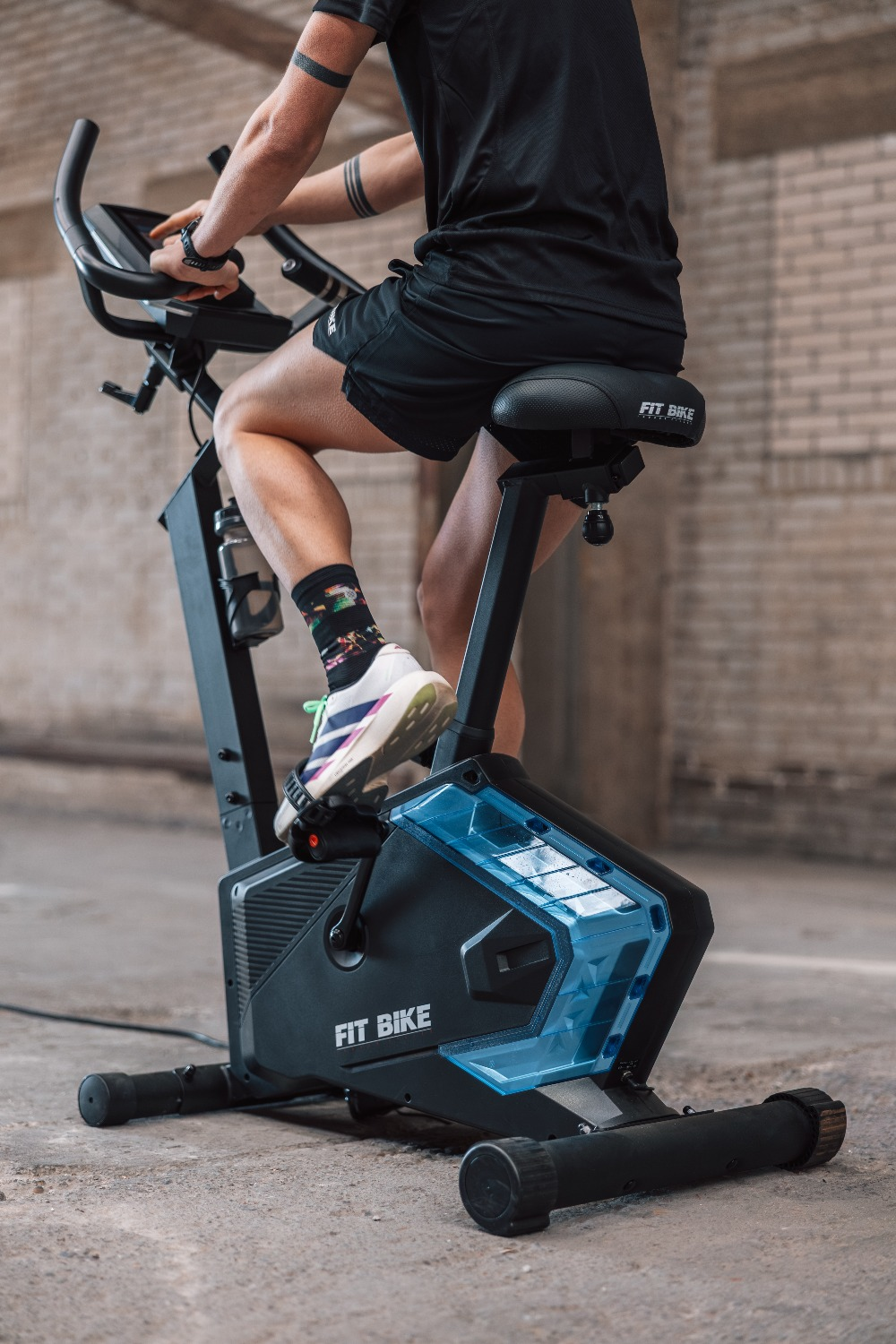 Een persoon op een zwarte hometrainer met blauwe accenten.