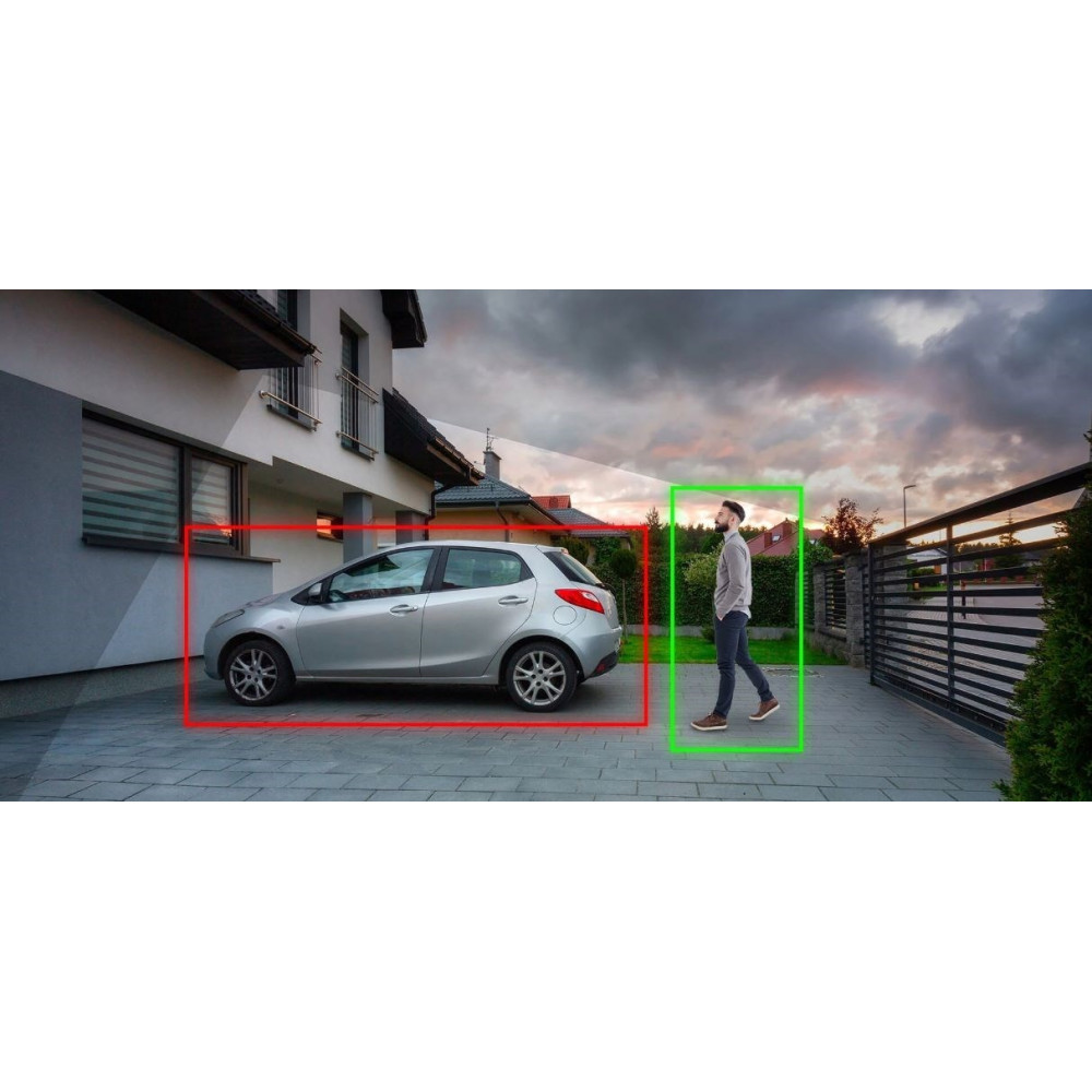 Mężczyzna przechodzi obok srebrnego samochodu zaparkowanego przed domem.