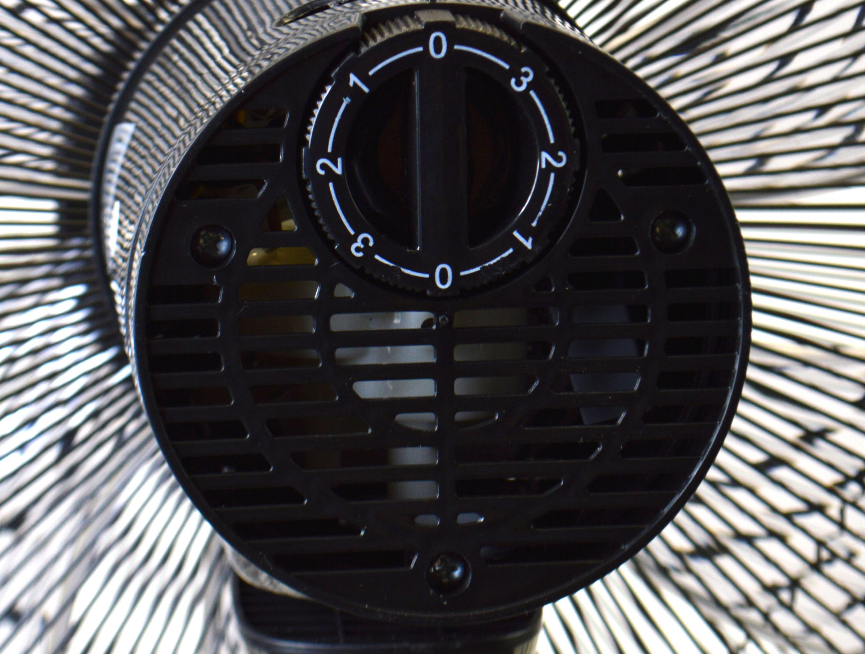 Ventilatore nero con quadrante della velocità e pale sullo sfondo.