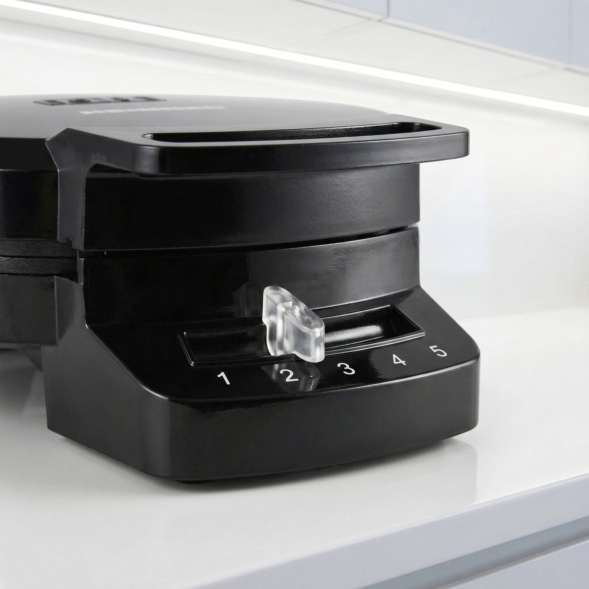 Black waffle maker with a numbered dial from 1 to 5.