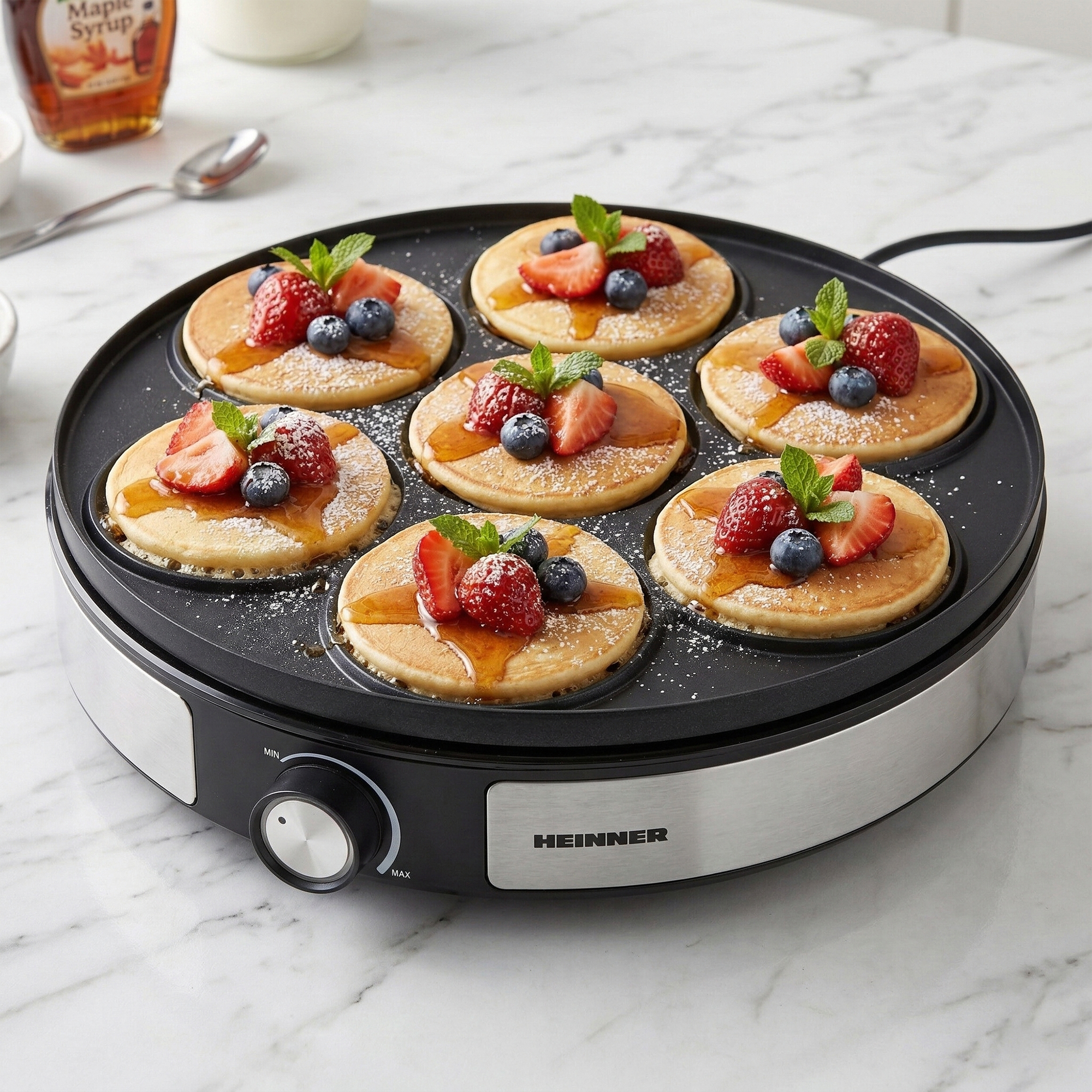 Pancakes with berries and mint on an electric griddle.