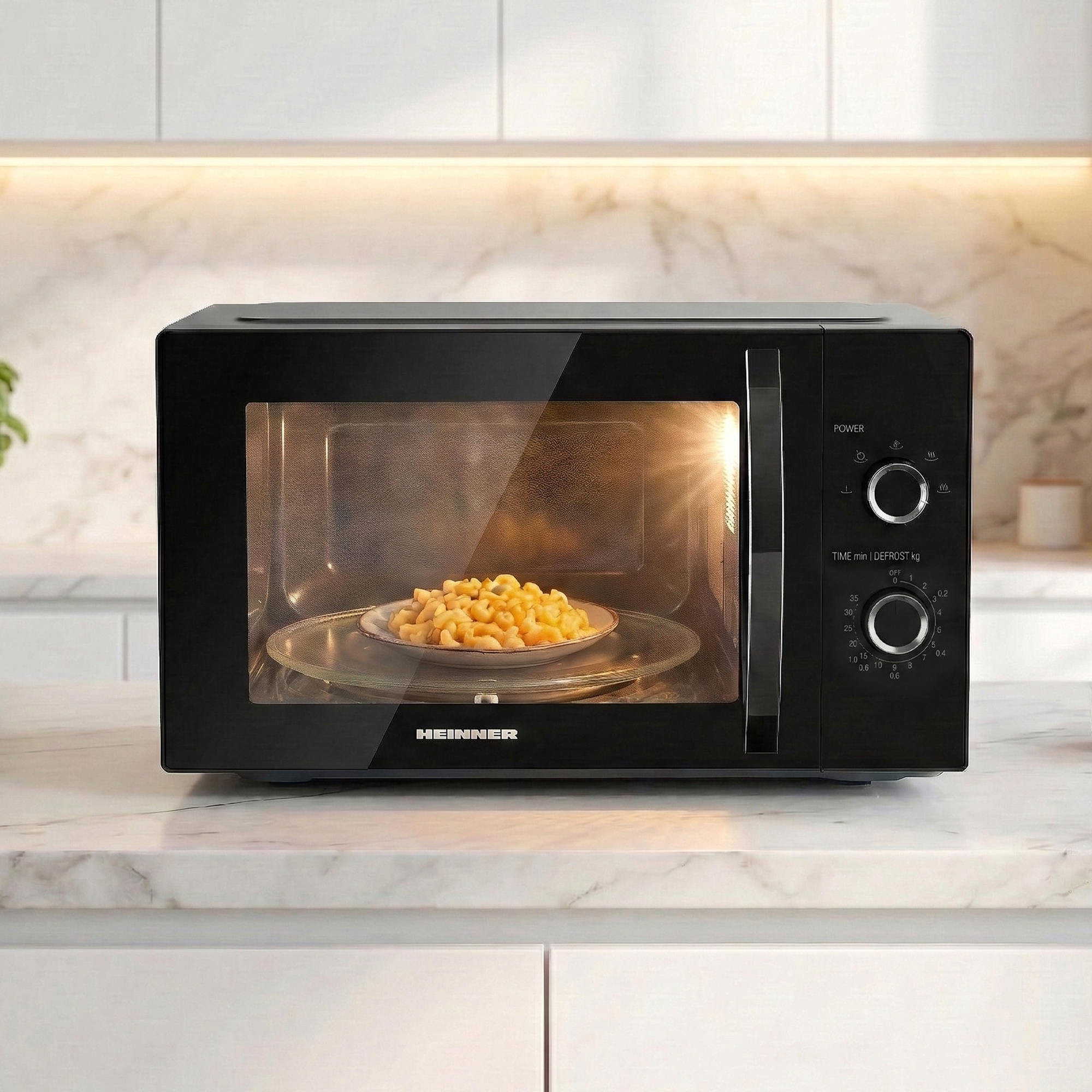 Black microwave with a plate of pasta on the turntable inside.