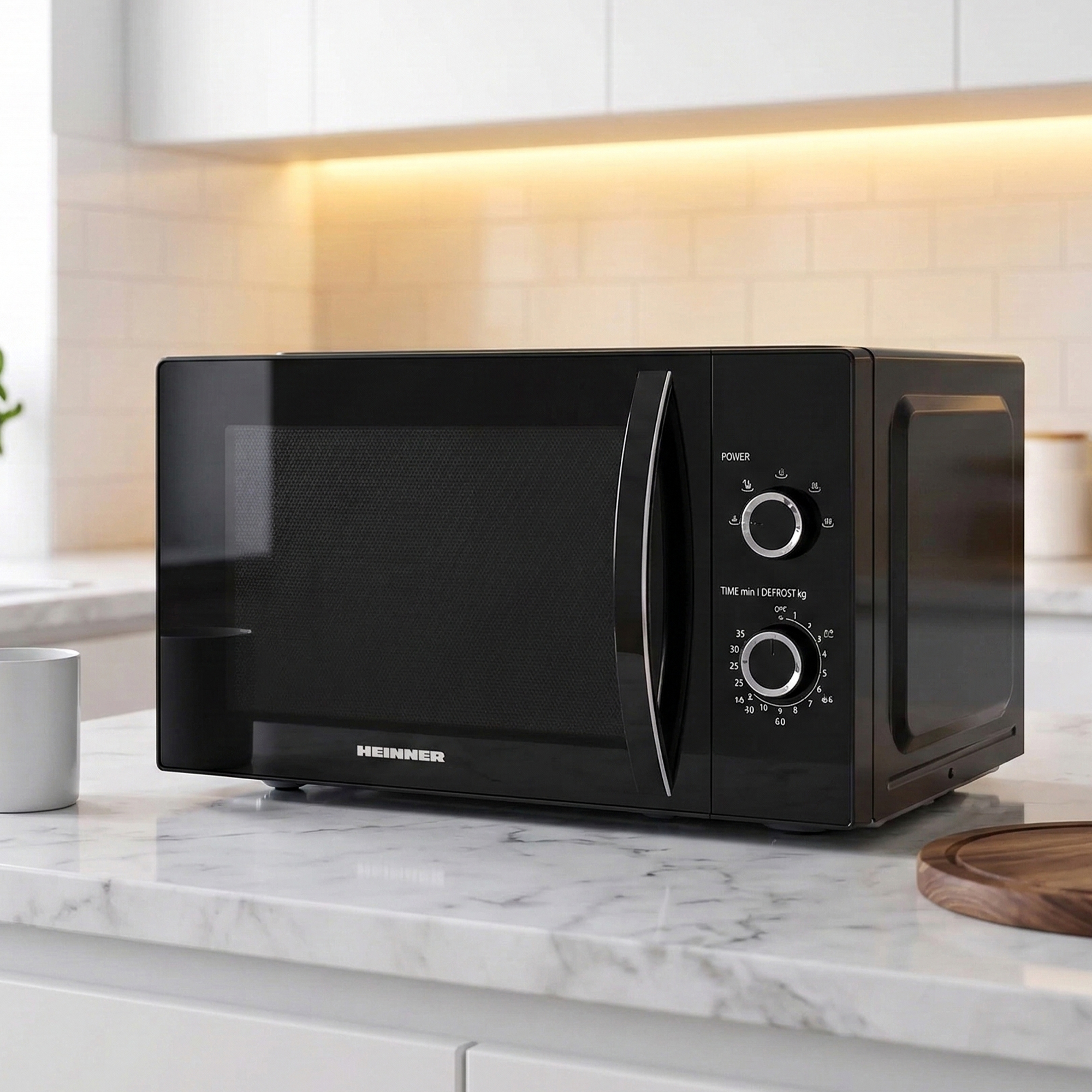 Black microwave with control knobs on a marble countertop.