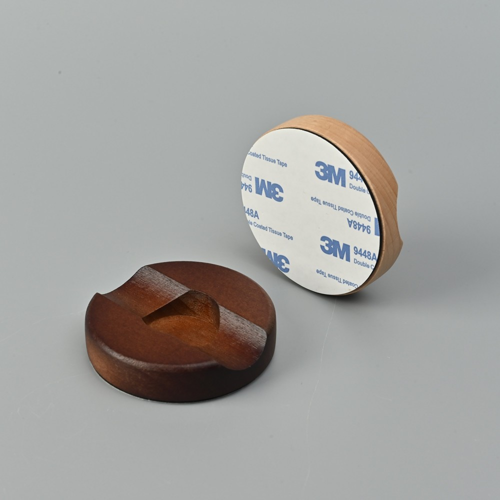 Dos piezas de madera sobre fondo gris, una con cinta 3M.