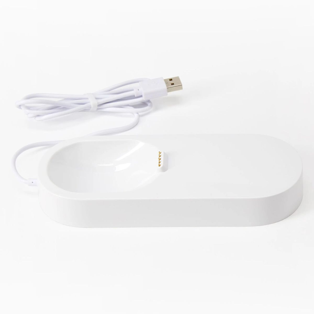 Una base de carga blanca con cable USB y pines de carga sobre fondo blanco.