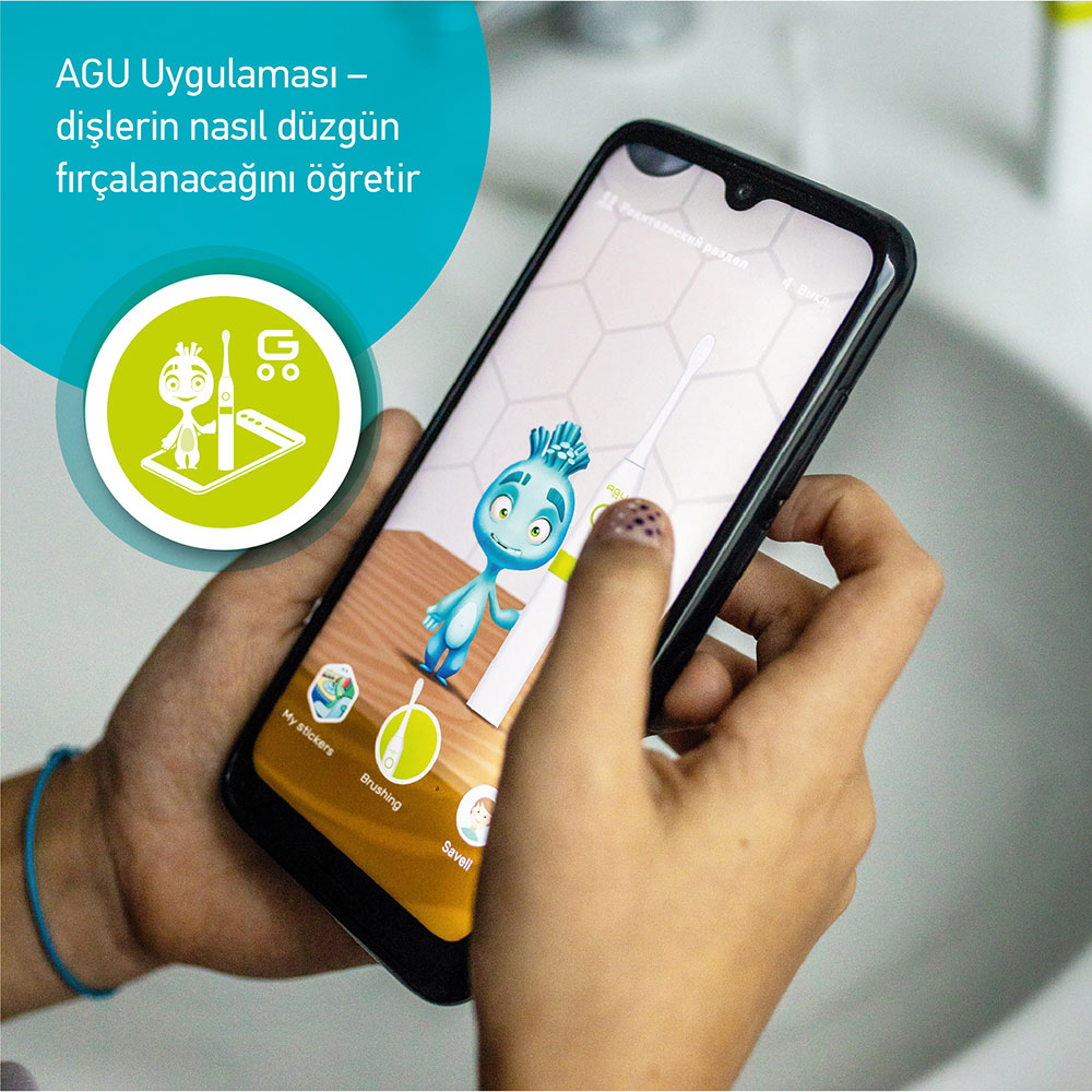 Kişi, çizgi film karakteri ve diş fırçası olan dişçilik uygulamasını gösteren telefonu tutuyor.