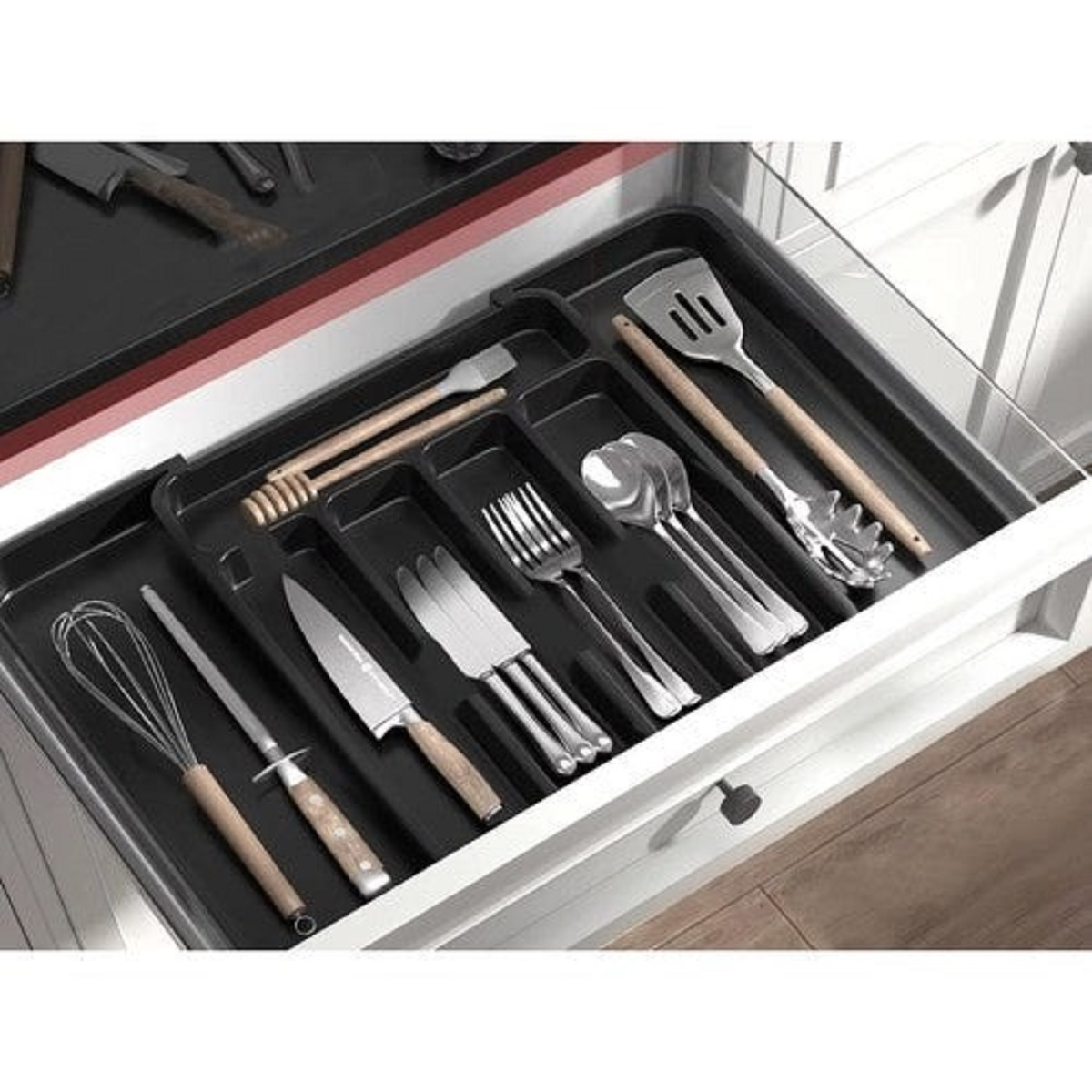 Un organizador de cajones de cocina con varios utensilios, incluidos batidora y cuchillos.