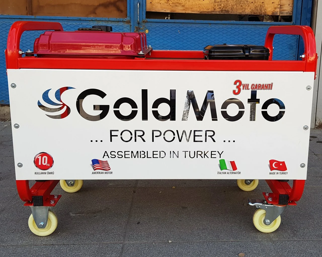 Tekerlekli, "Gold Moto" logolu kırmızı ve beyaz jeneratör.