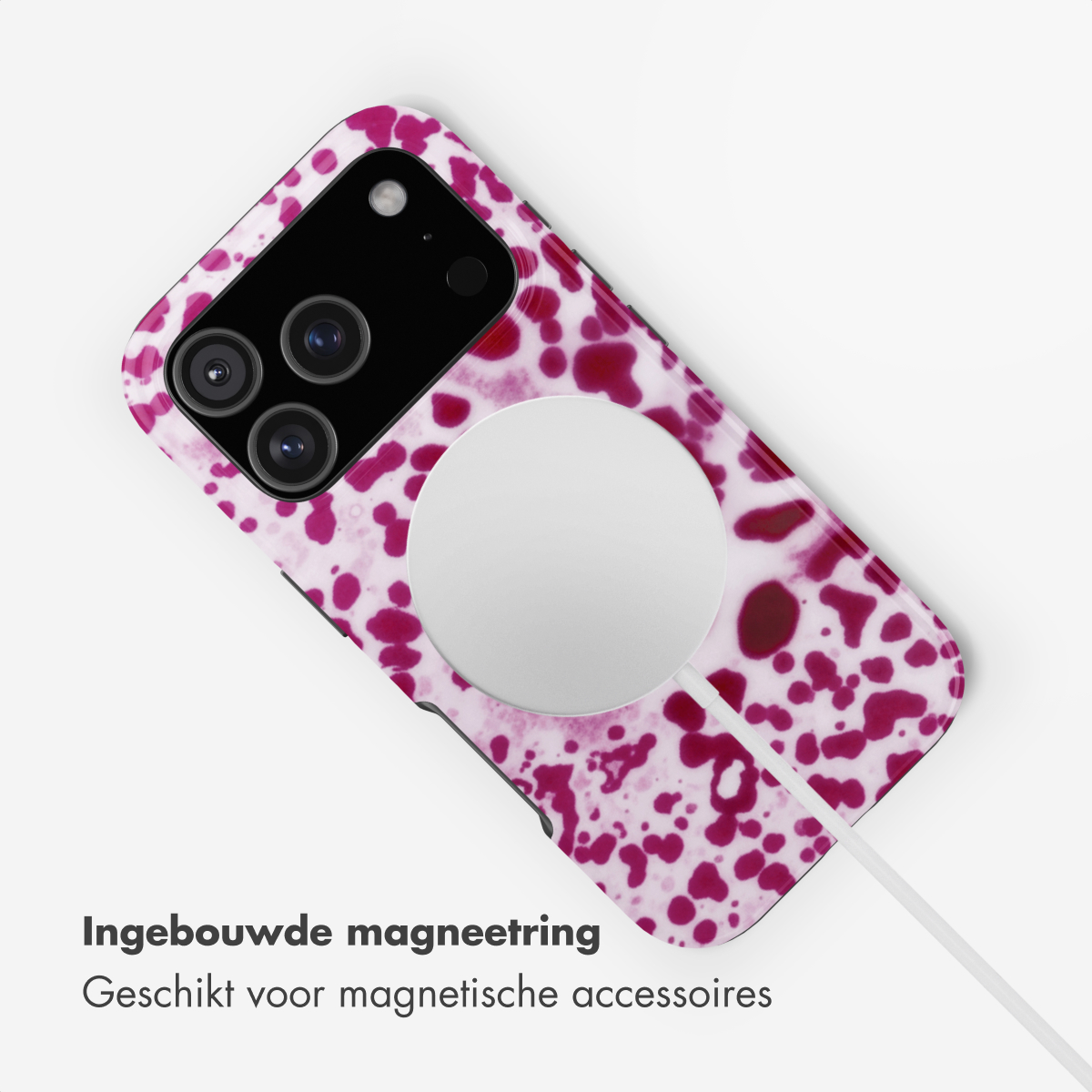 Un telefono con fantasia rosa e bianco con caricatore MagSafe e cavo.