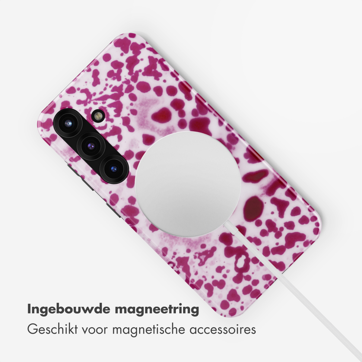 Een telefoon met een roze en wit gevlekt patroon, met een witte cirkel en kabel.