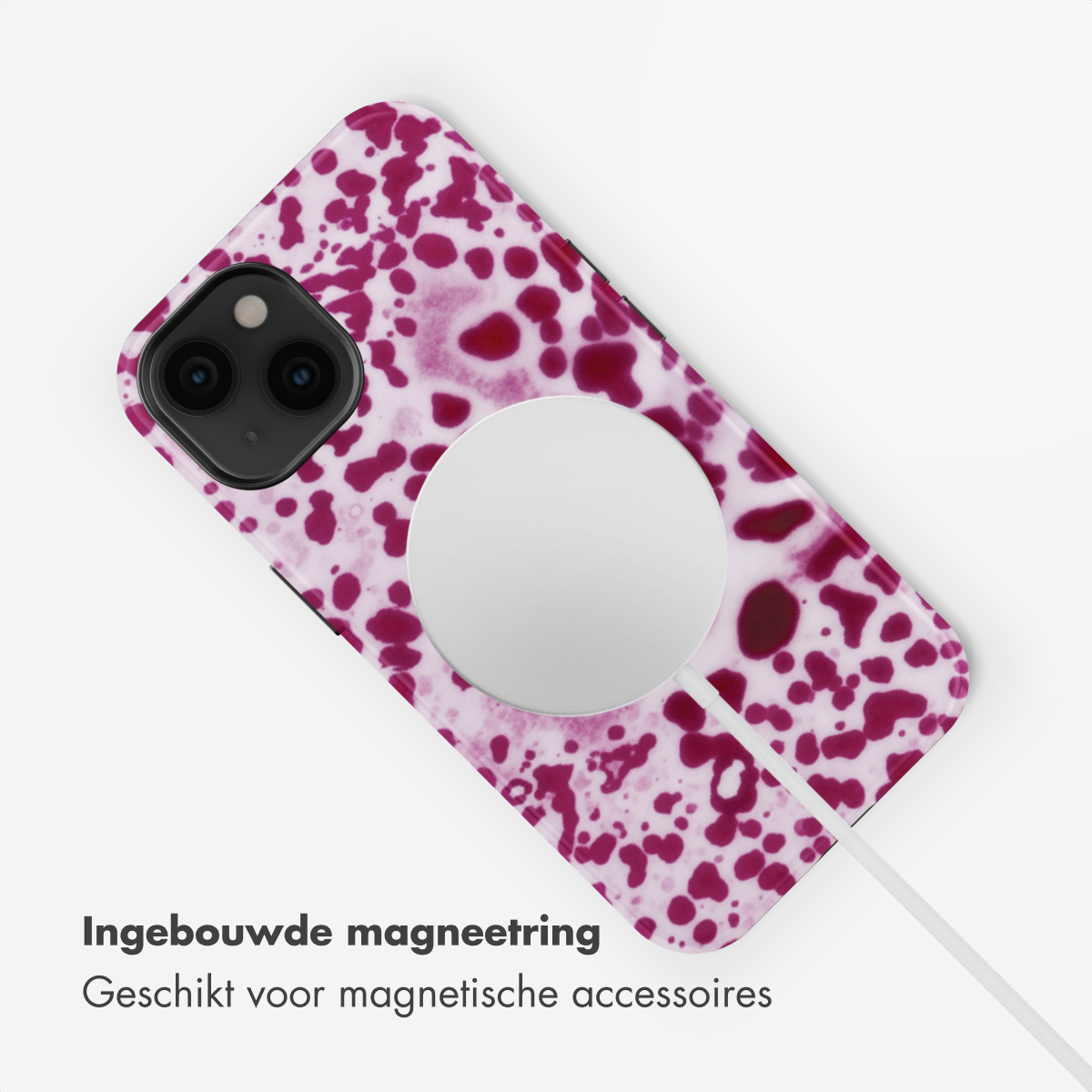 Un iPhone maculato di viola e bianco con un caricatore MagSafe bianco.