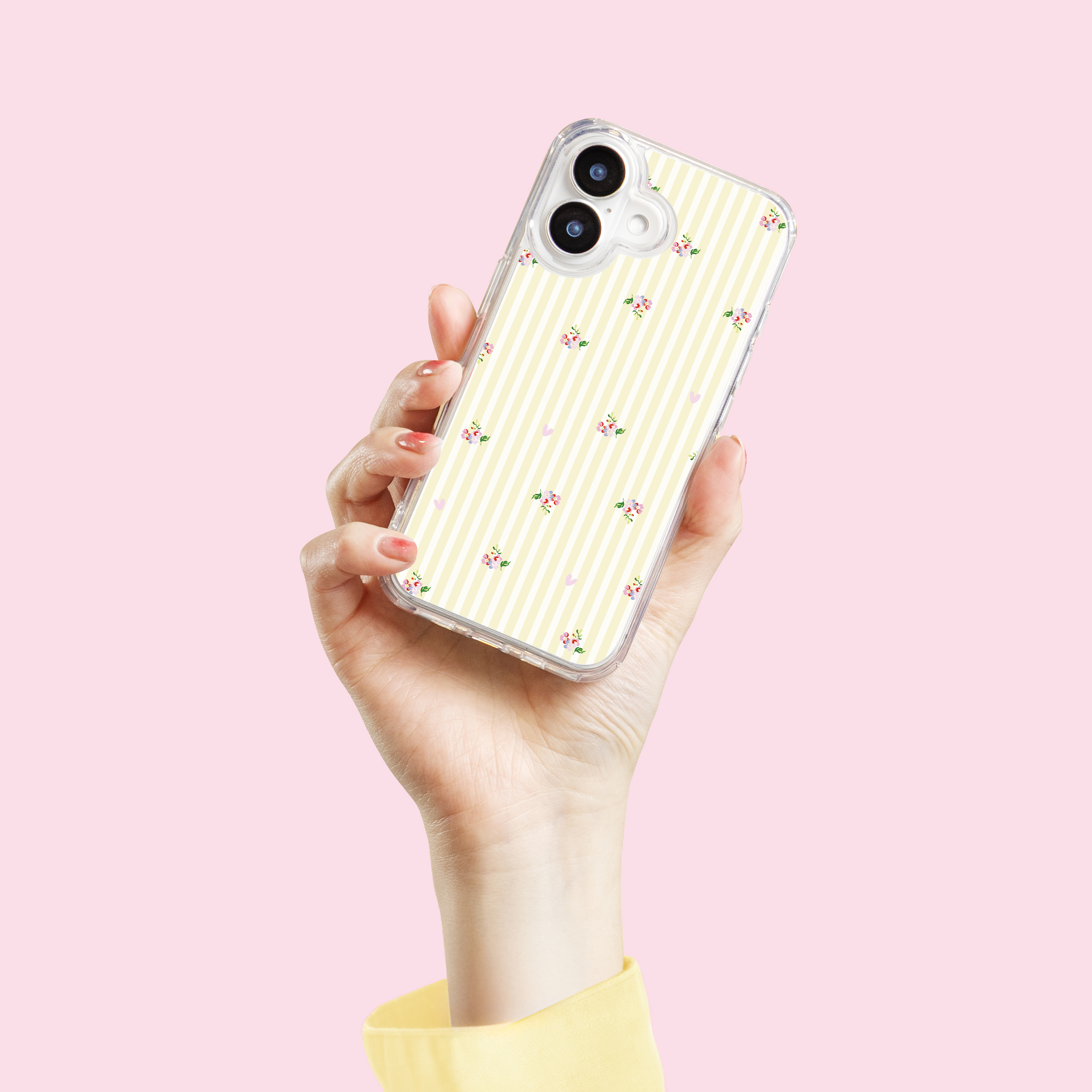 Een hand houdt een doorzichtige telefoonhoes met gele strepen en bloemenpatroon.