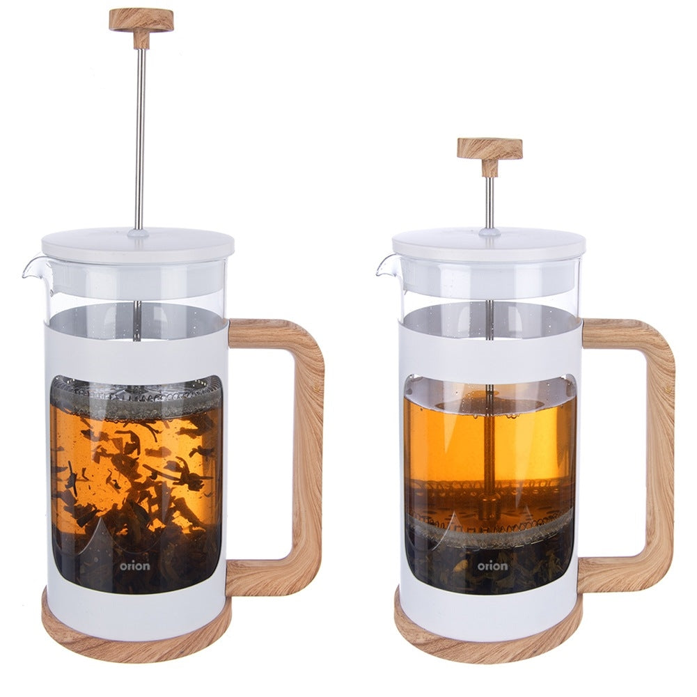 Dos jarras de prensa francesa blancas con mangos de madera, una con té, otra con agua.