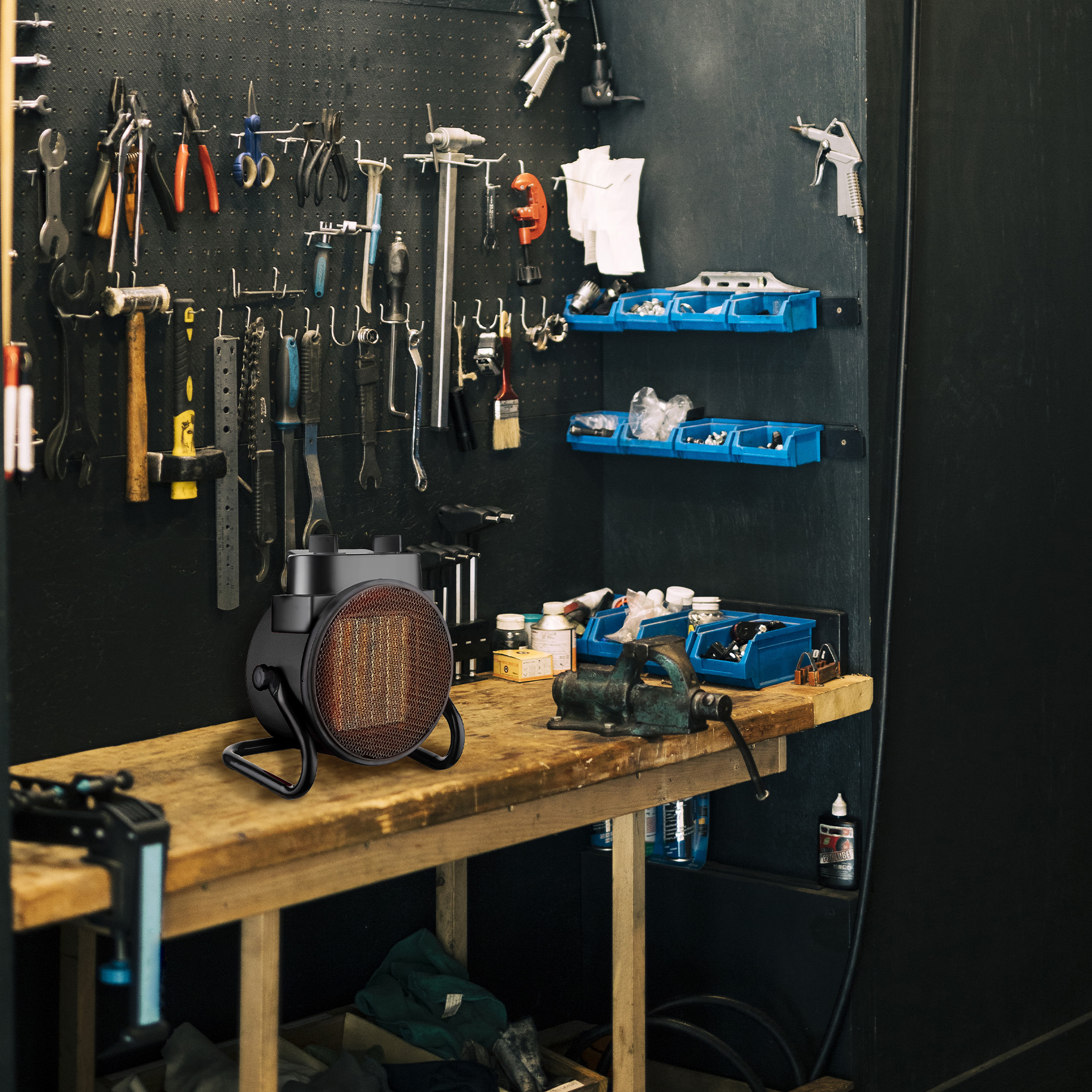 Werkstatt mit Werkzeugen an der Wand, einem Heizstrahler und Schraubstock auf dem Tisch.