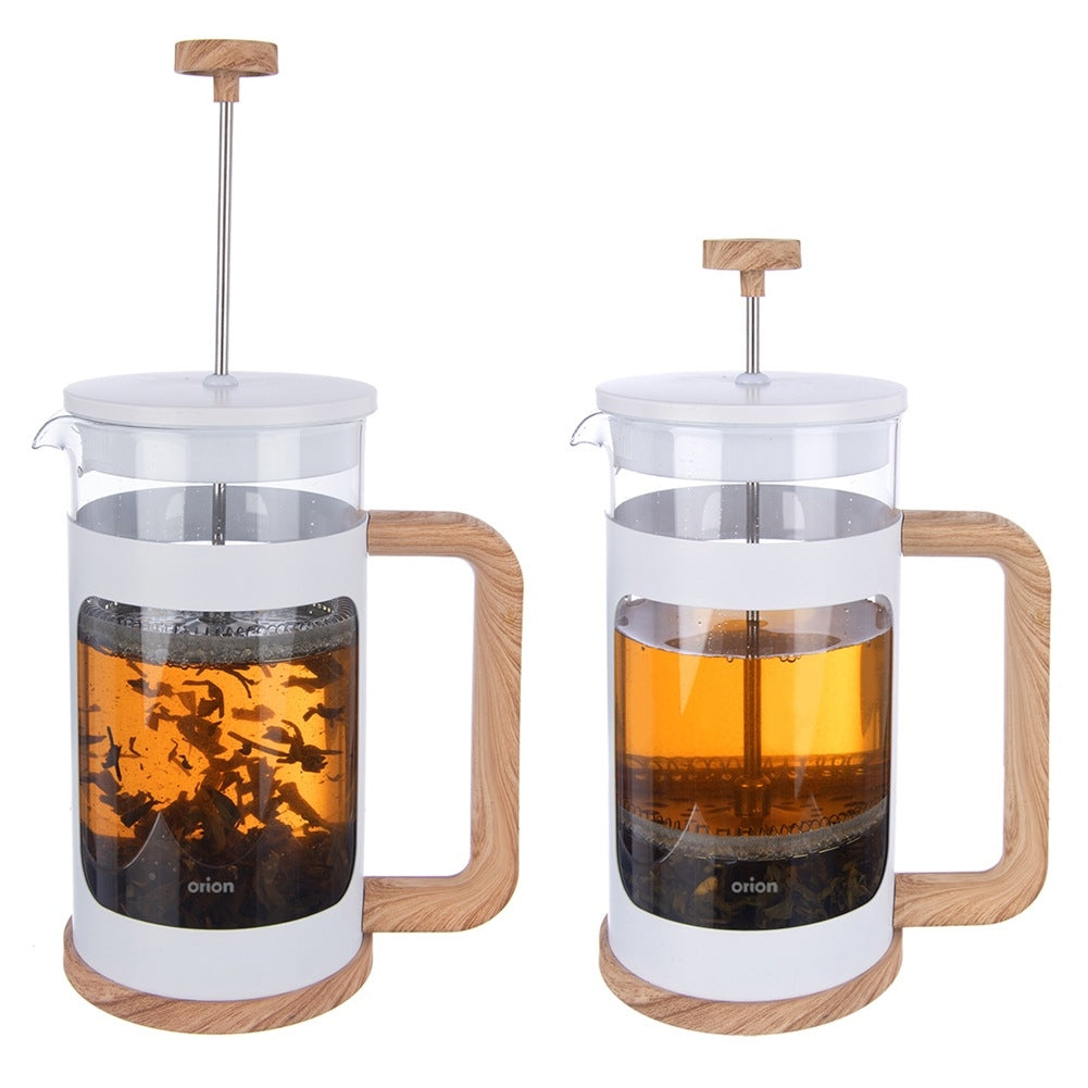 Dos jarras de prensa francesa blancas con detalles de madera y té.