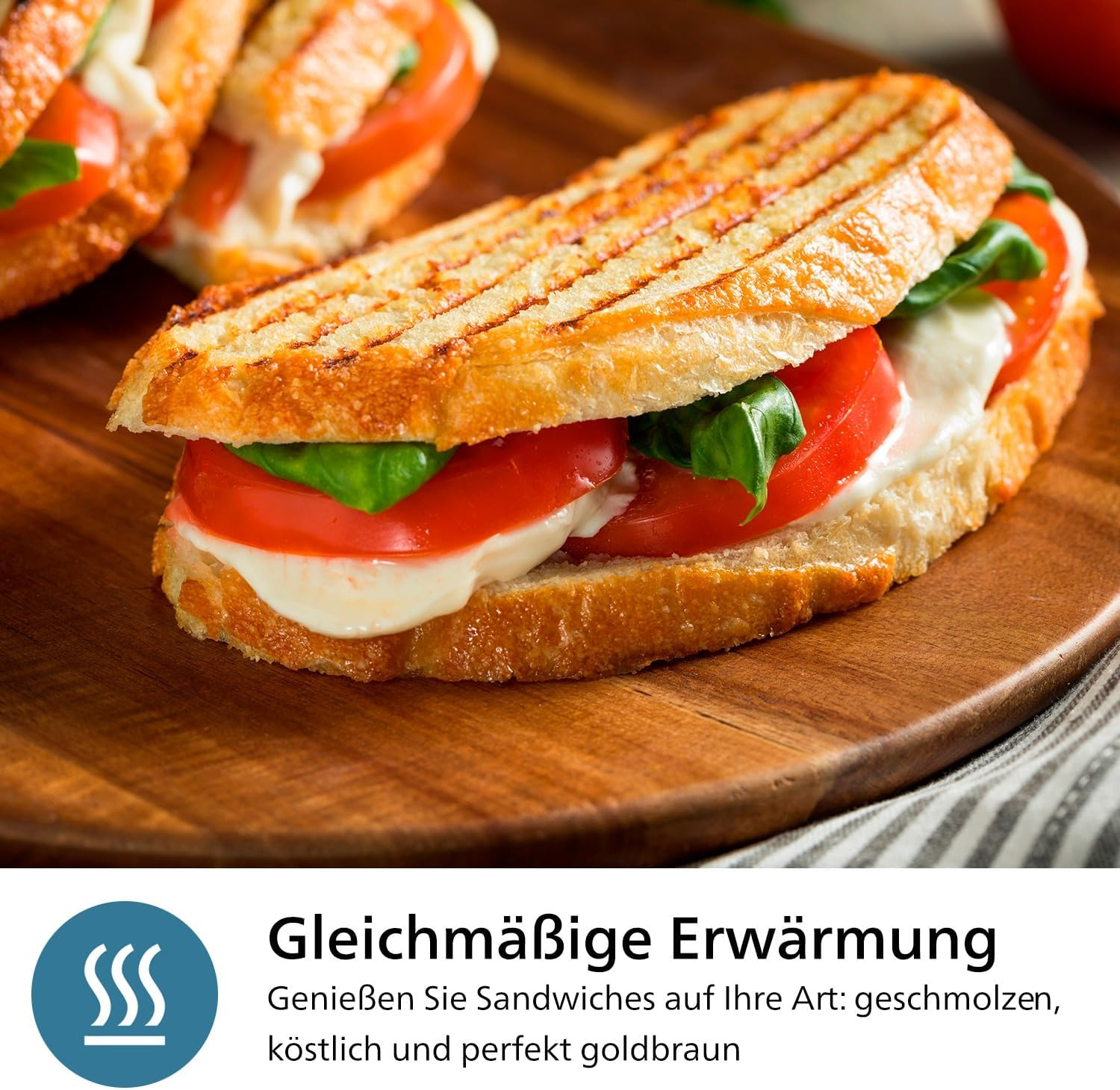Ein gegrilltes Sandwich mit Tomaten, Mozzarella und Basilikum auf einem Holzbrett.