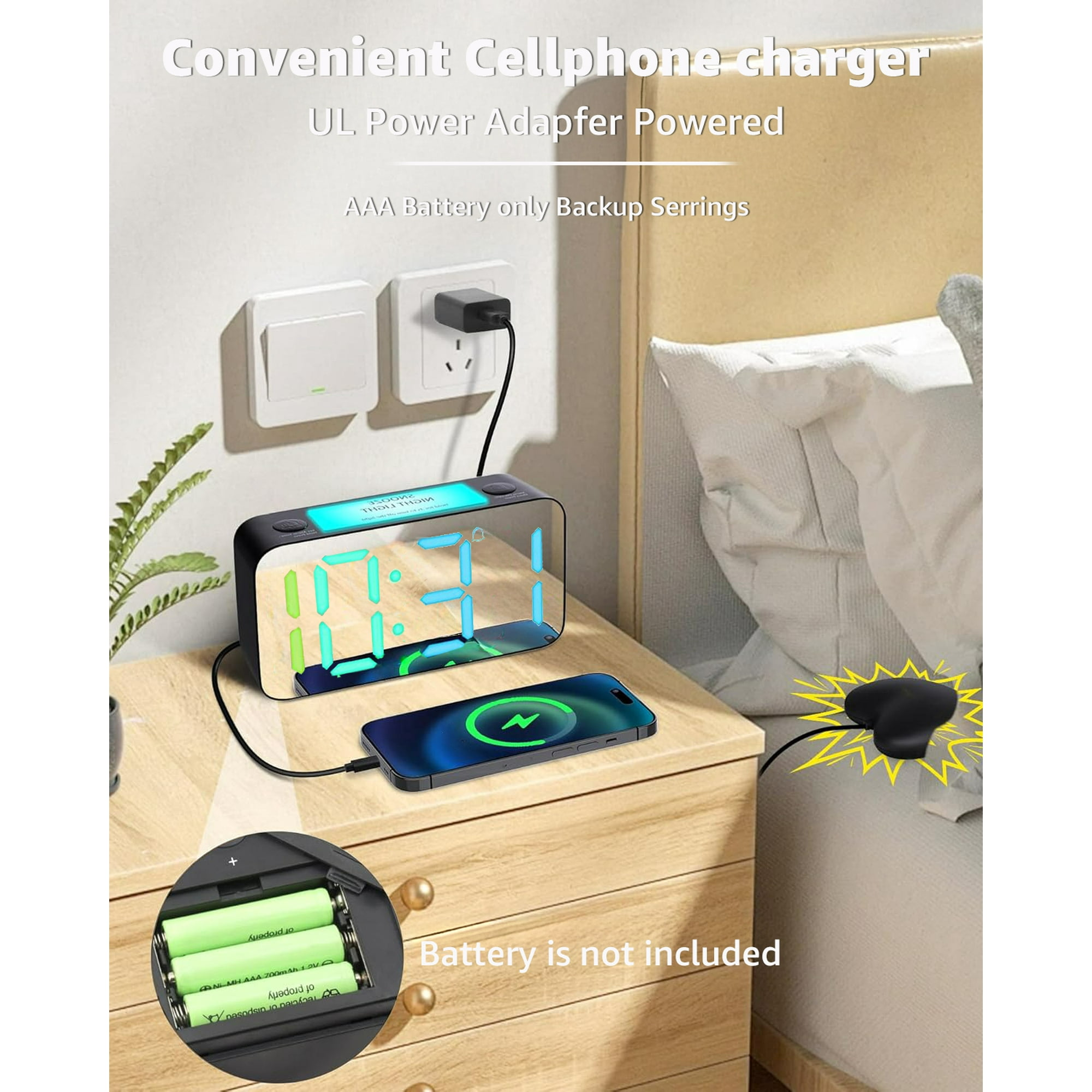Ein digitaler Wecker mit farbigem Display, der ein Smartphone lädt. Batteriefach geöffnet.