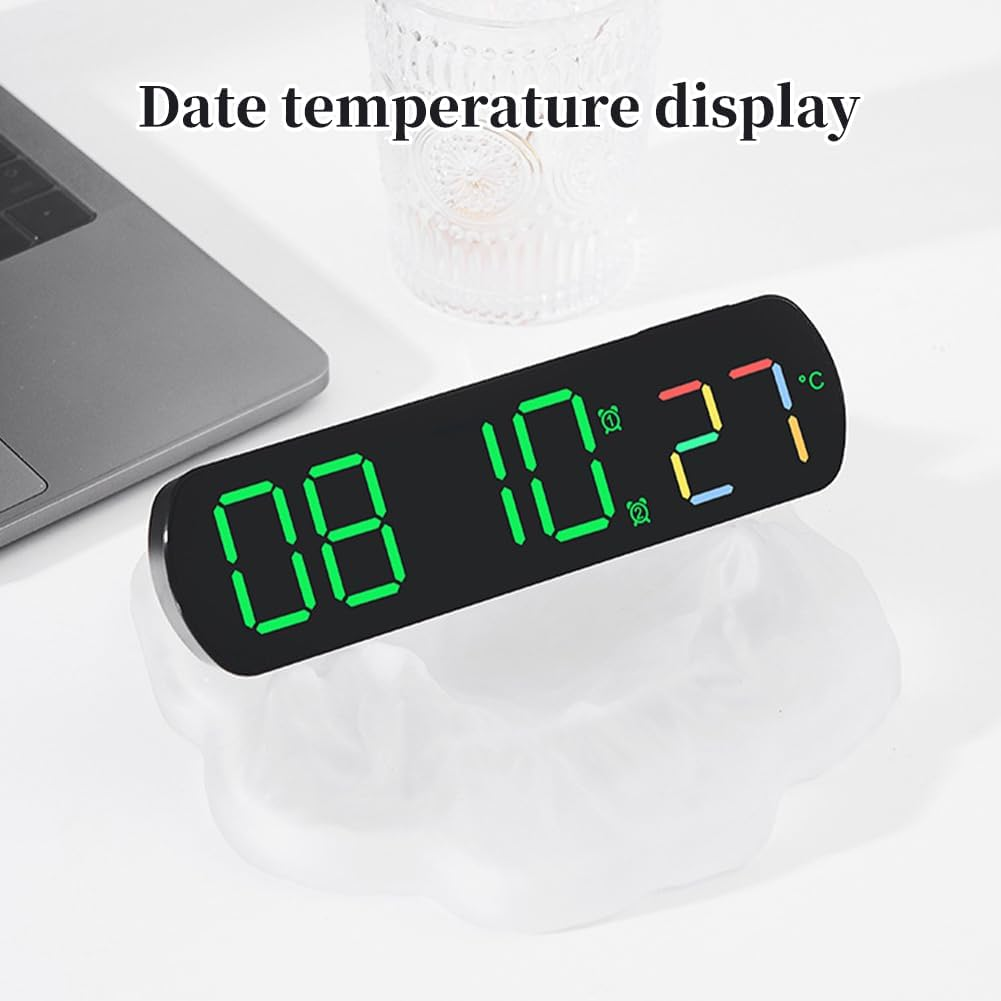 Eine Digitaluhr zeigt 08:10:27 in Grün und Rot an. Ein Laptop ist in der Nähe.