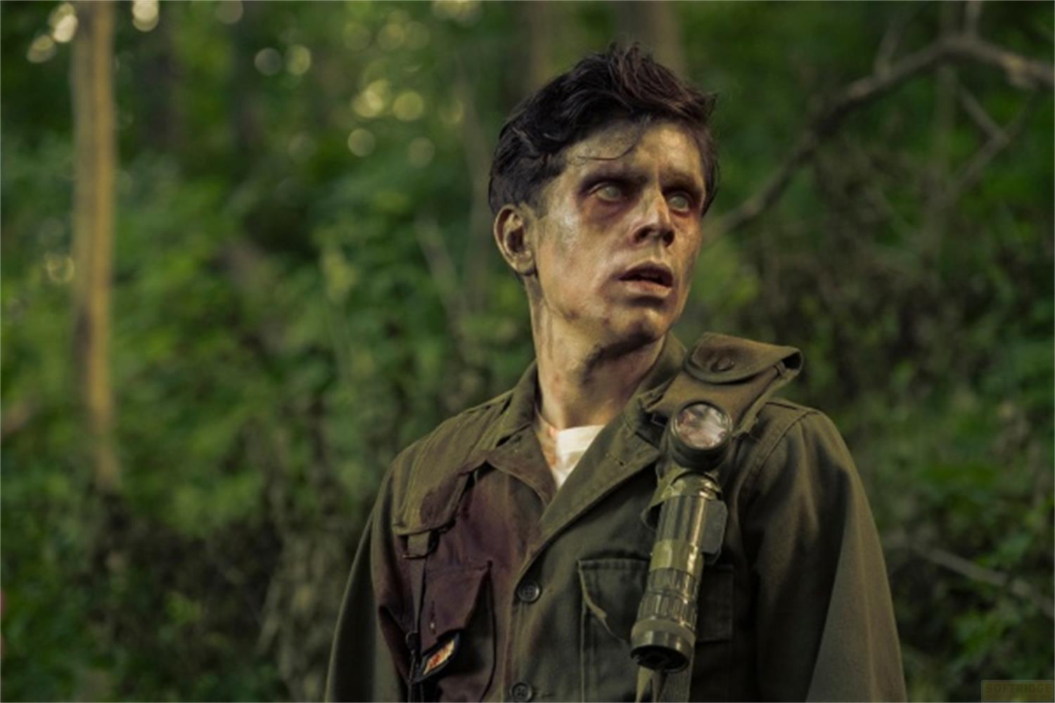 Un uomo dalla pelle pallida e dagli occhi bianchi indossa un'uniforme militare con una torcia.