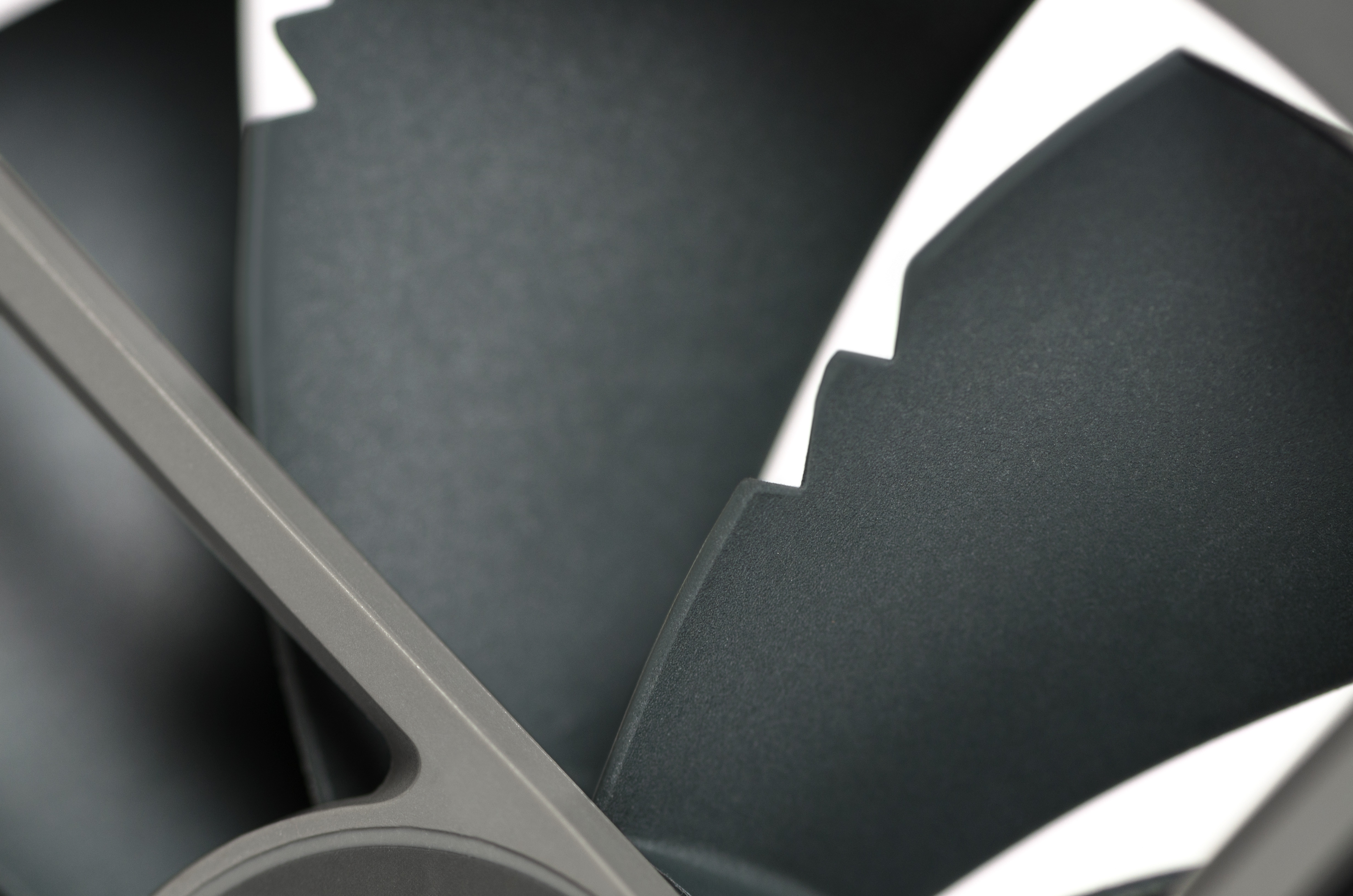 Zbliżenie ciemnych łopat wentylatora na białym tle.