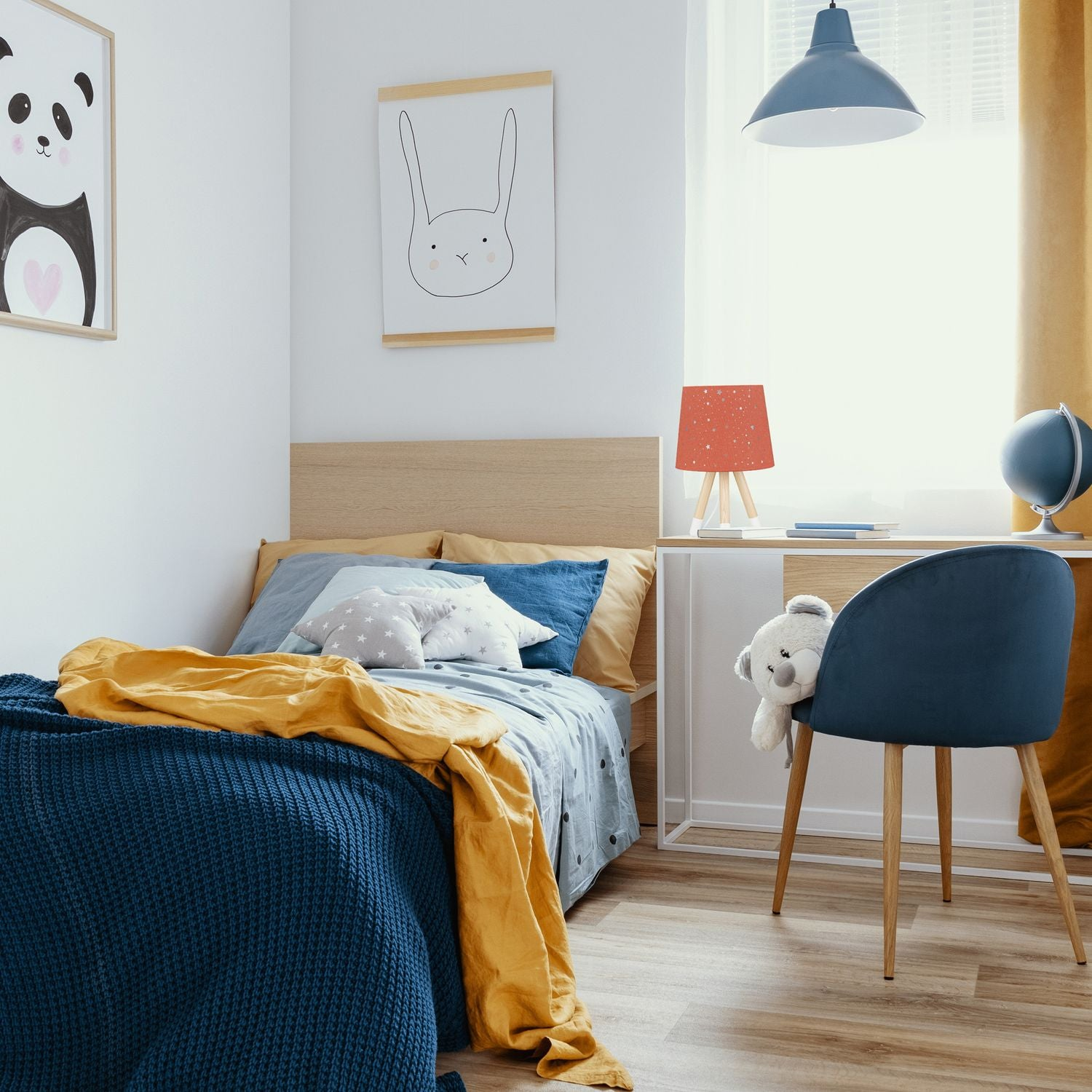 Dormitorio infantil con cama, escritorio, silla y arte de pared.