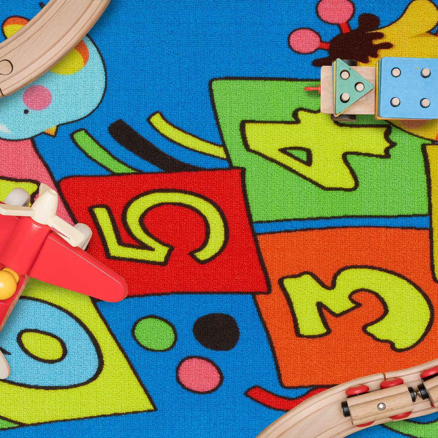 Alfombra de juegos colorida con números y juguetes: avión, tren de madera.